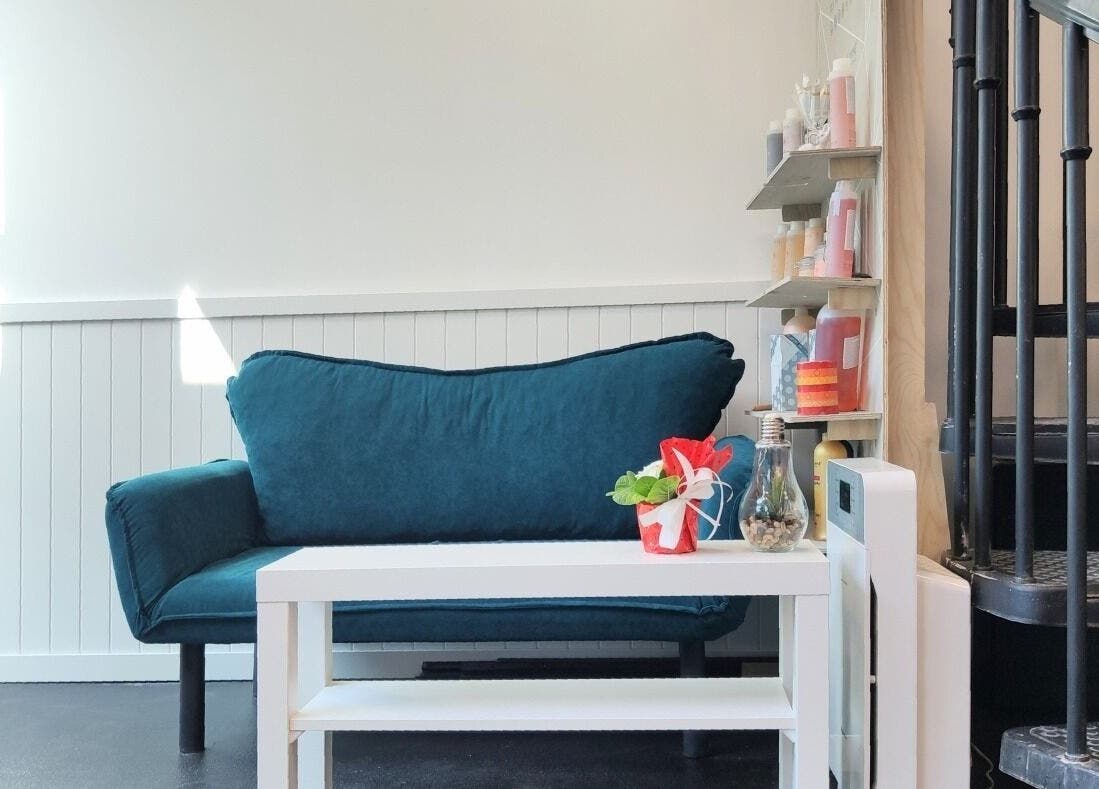 Relaxing corner in Фризьорски Салон 'Wave Studio' - НДК, Sofia, Sofia City Province, BG with a blue sofa and spiral stair.