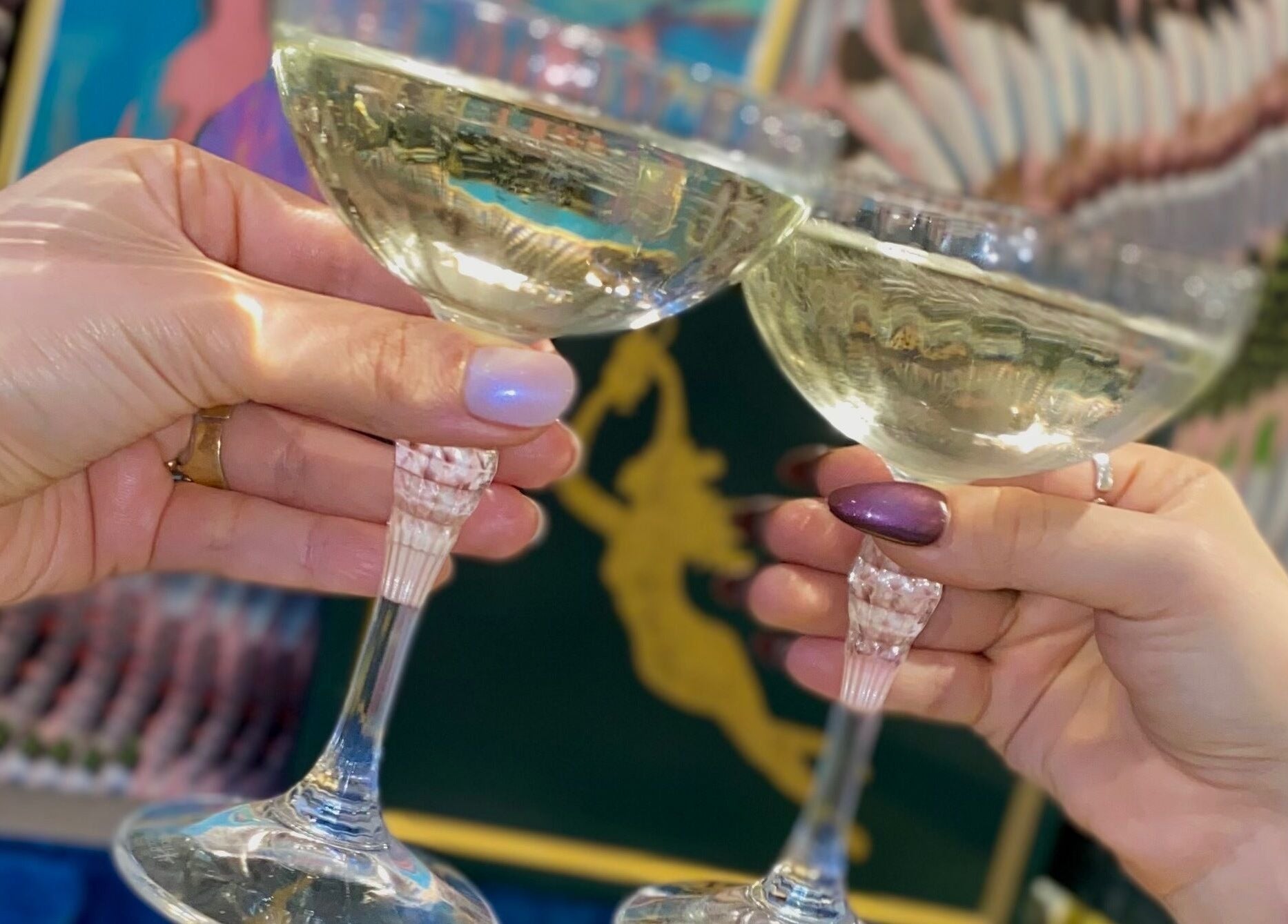 Two hands toasting with glasses at Iris Avenue, London, England, GB, symbolizing celebration.