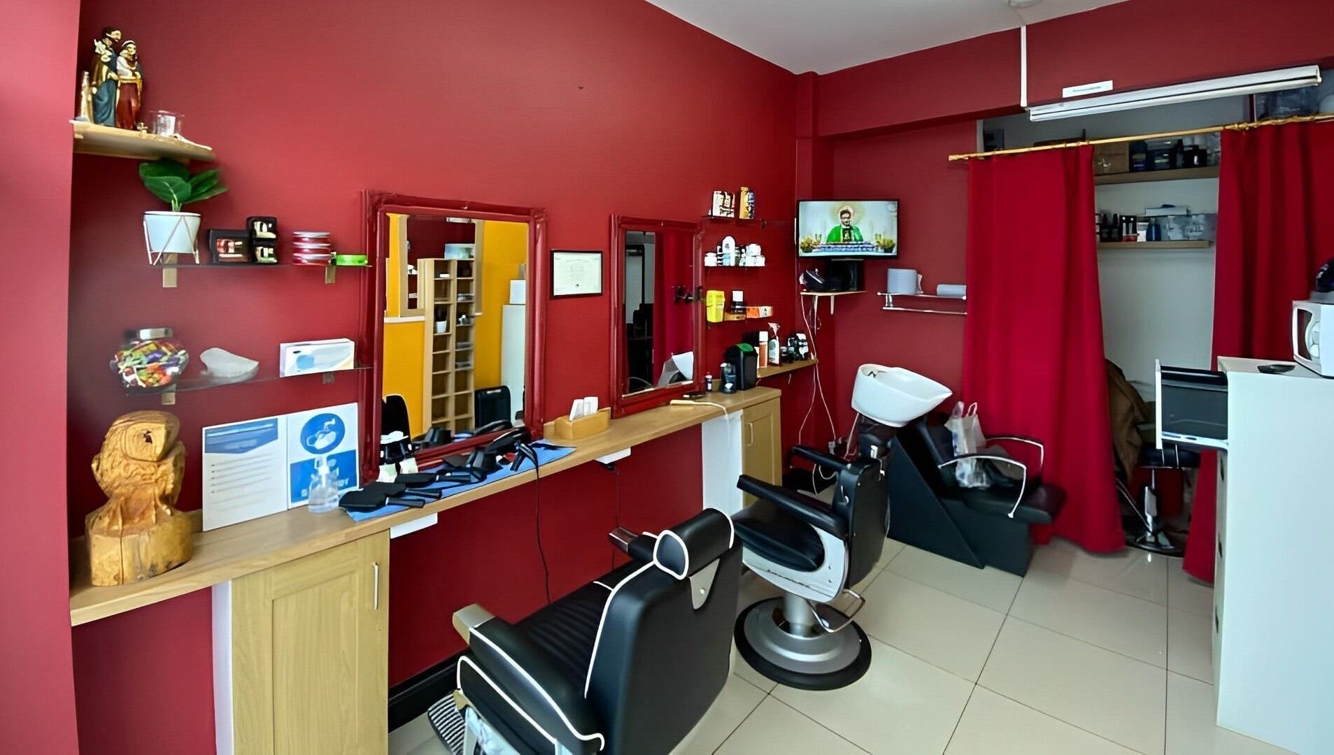 Soorya Barbers in Harrow, England offers a modern interior with red walls and barber chairs.