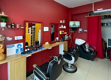 Soorya Barbers in Harrow, England offers a modern interior with red walls and barber chairs.