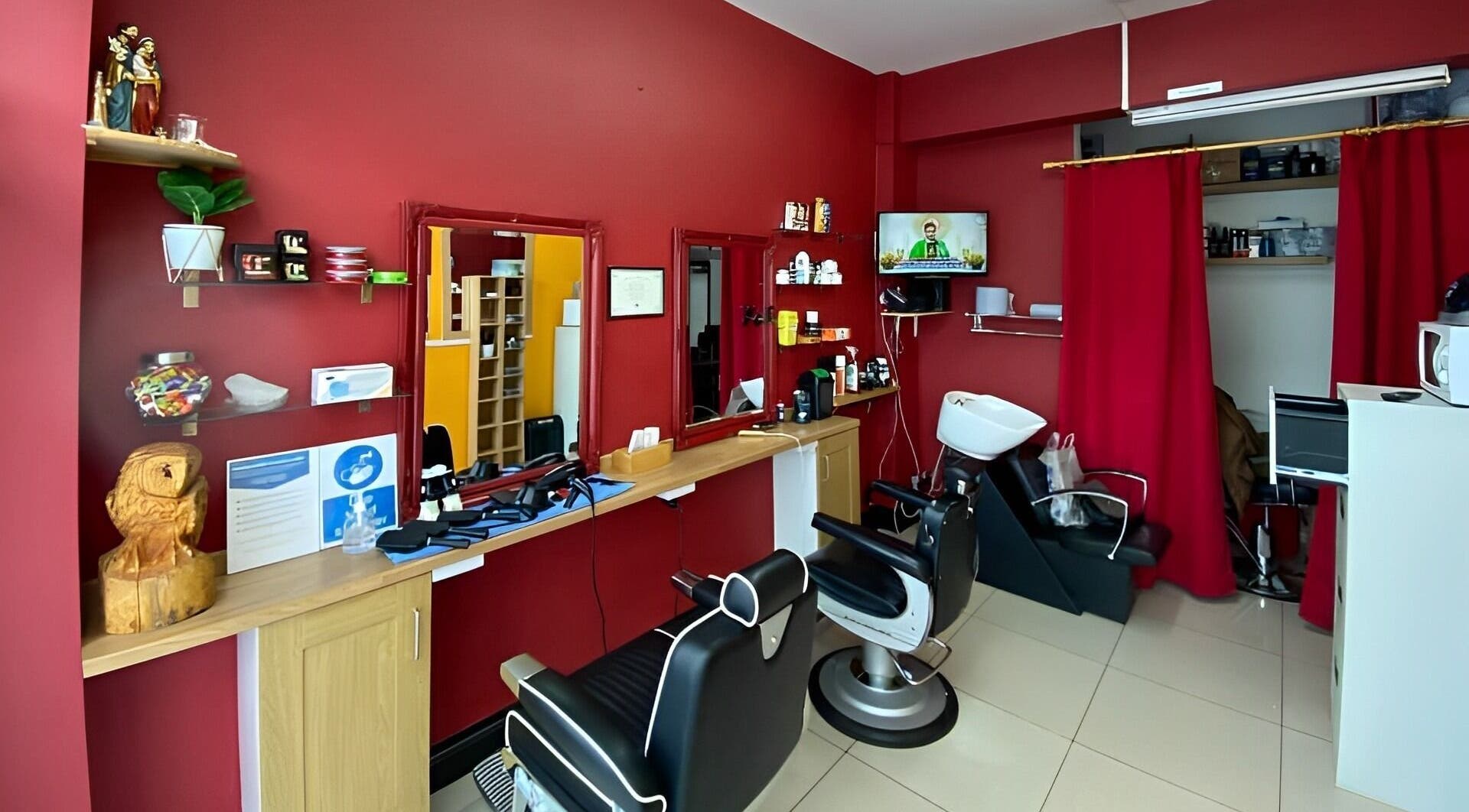 Soorya Barbers in Harrow, England offers a modern interior with red walls and barber chairs.