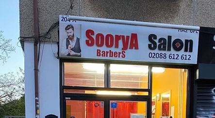 Exterior view of Soorya Barbers located in Harrow, England, GB at dusk with illuminated sign.
