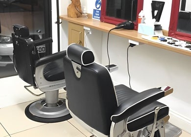 Modern barber chairs at Soorya Barbers, Harrow, England, GB offering a sleek and stylish grooming experience.