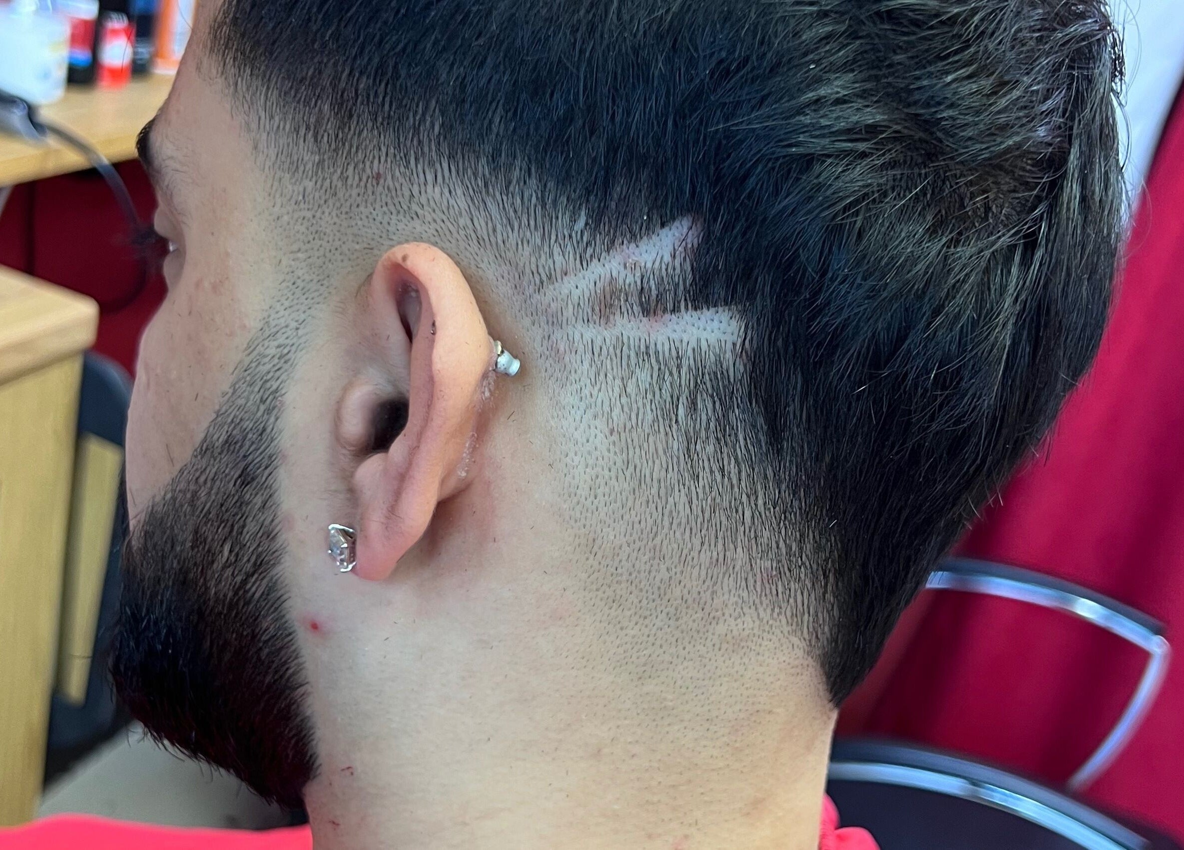 Detailed side view of a creative fade design at Soorya Barbers, Harrow, England, GB.