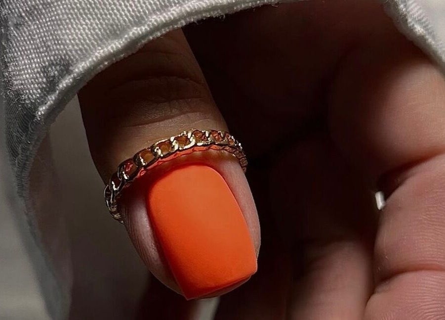 Close-up of a stylish orange nail with a gold ring, crafted at Saidi Nails, Limassol, Limassol, CY.