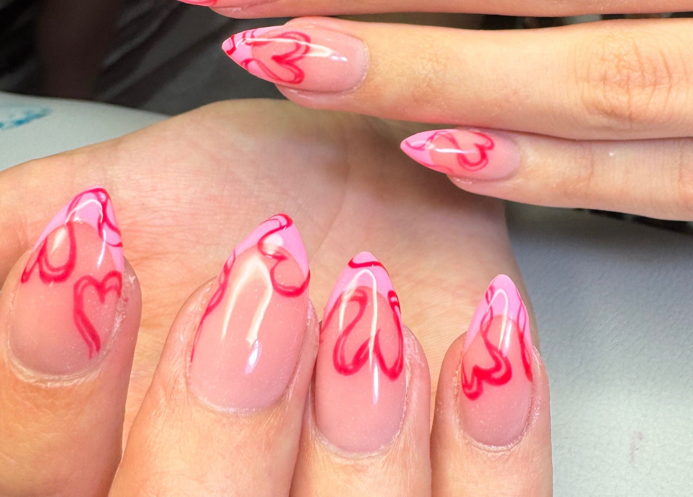 Stylish heart-tipped nail art on hands at Amity Beauty Salon, Potchefstroom, North West, ZA.