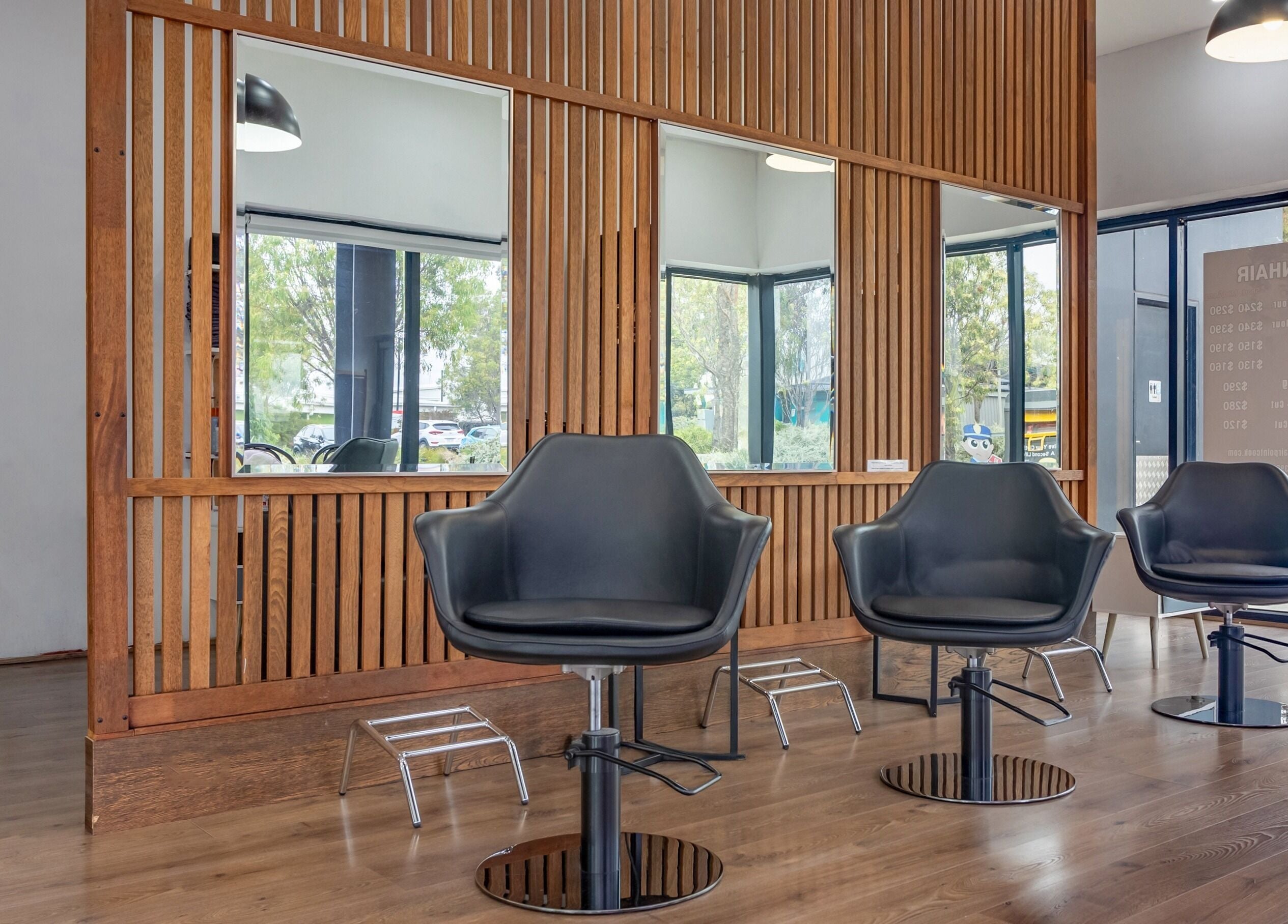 Modern salon chairs at Ribbon Hair - Point Cook, Melbourne, Victoria, AU with sleek wooden accents.