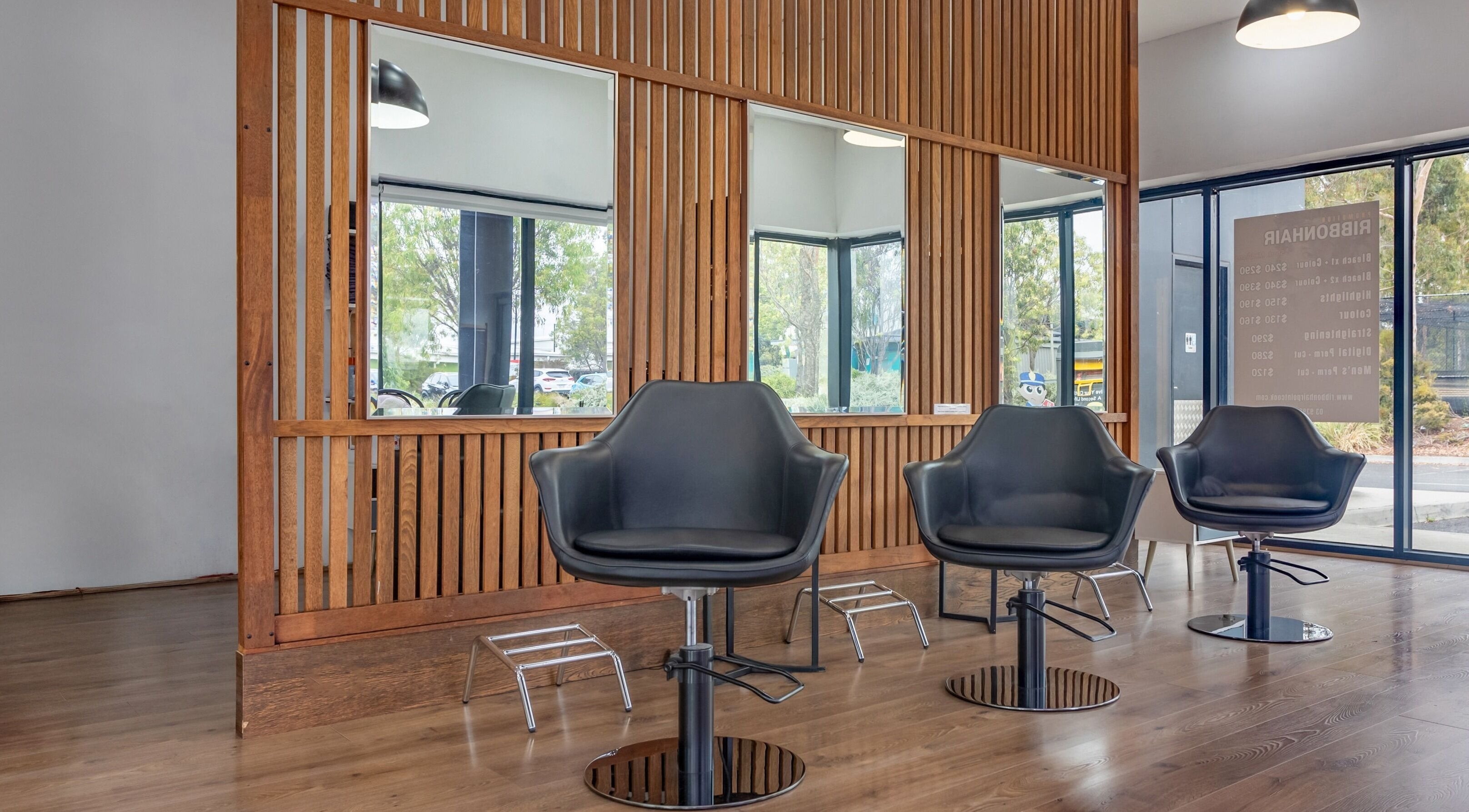Modern salon chairs at Ribbon Hair - Point Cook, Melbourne, Victoria, AU with sleek wooden accents.