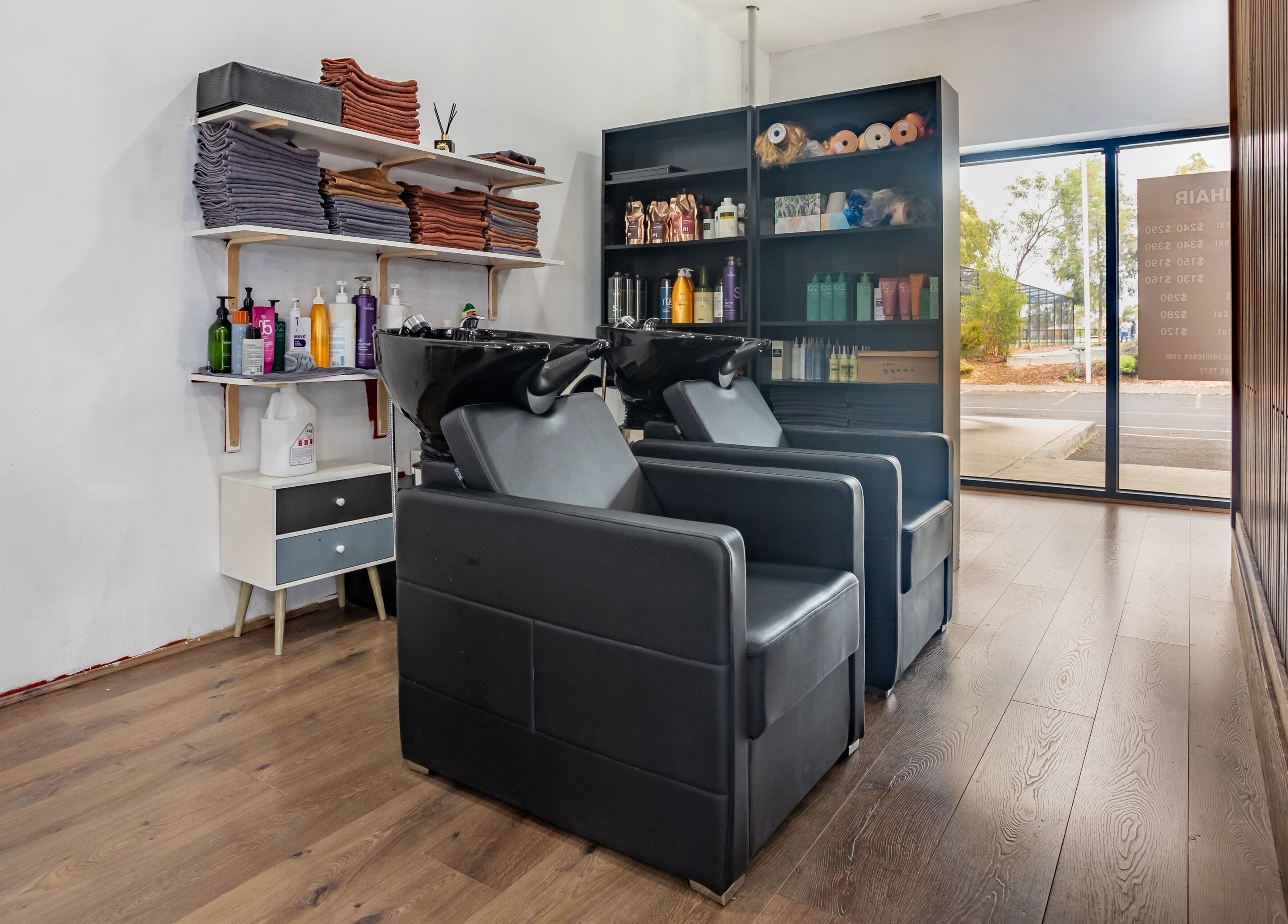 Elegant hair washing station at Ribbon Hair - Point Cook in Melbourne, Victoria, AU, with modern black chairs.