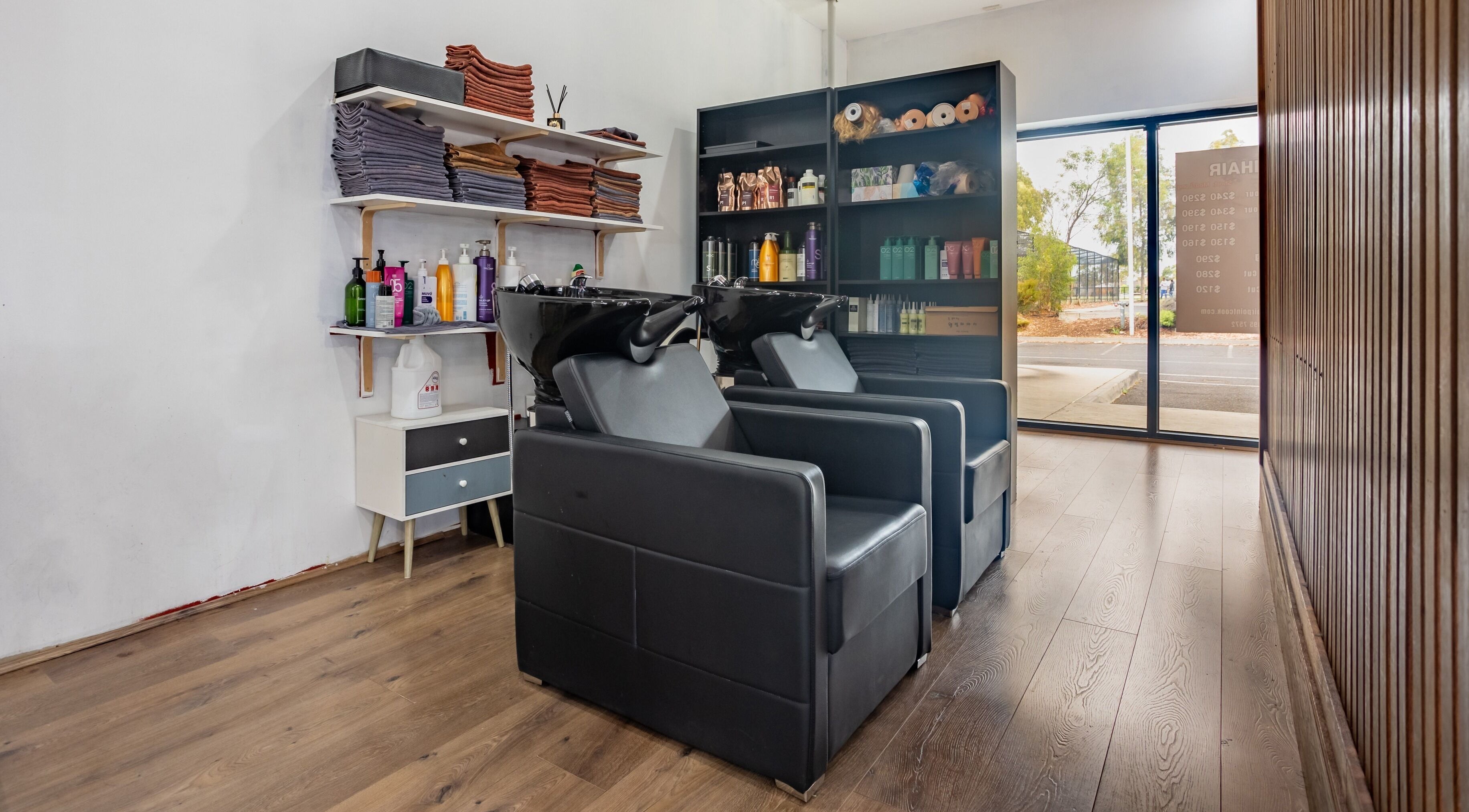 Elegant hair washing station at Ribbon Hair - Point Cook in Melbourne, Victoria, AU, with modern black chairs.