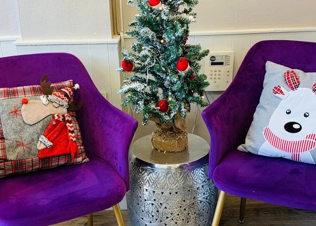 Cozy seating area at Mac Hair, Southampton, England, GB, with festive decor and plush purple chairs.