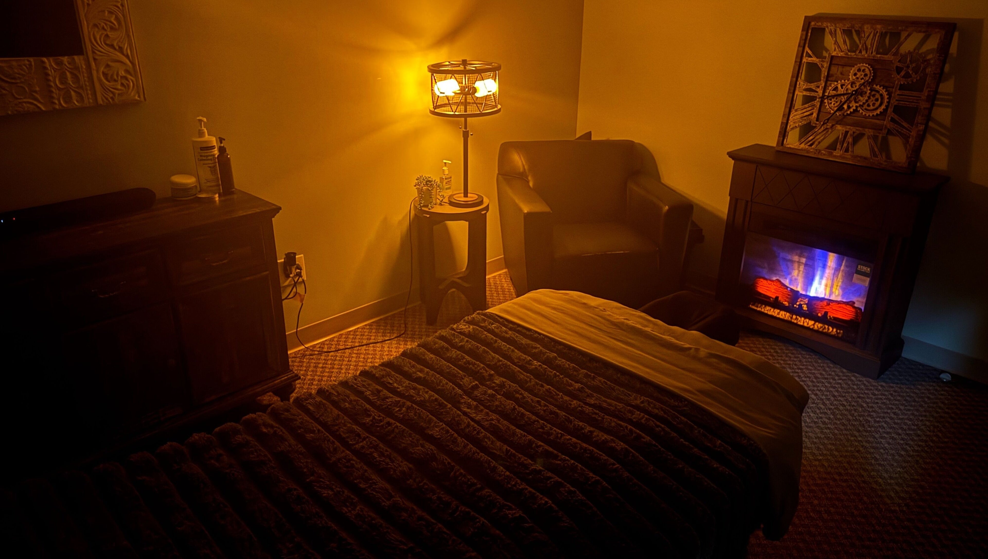 Warm massage room at Manna Medical Massage, Burton, Michigan, US, with ambient lighting and a cozy chair.