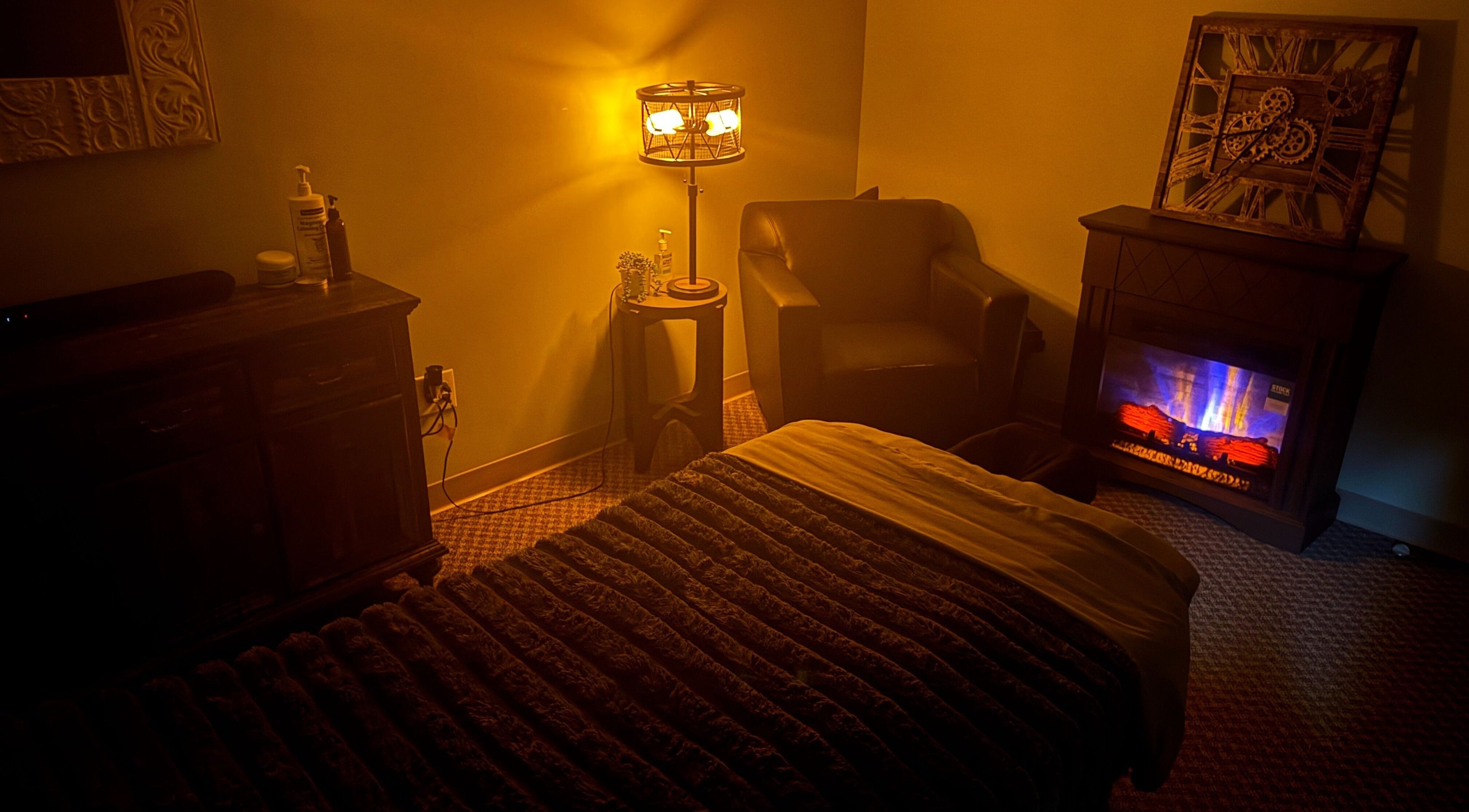 Warm massage room at Manna Medical Massage, Burton, Michigan, US, with ambient lighting and a cozy chair.