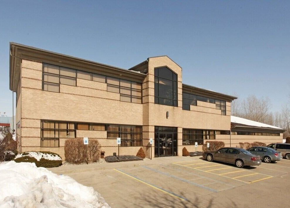 Exterior of Manna Medical Massage in Burton, Michigan, US, showcasing modern architecture and ample parking.