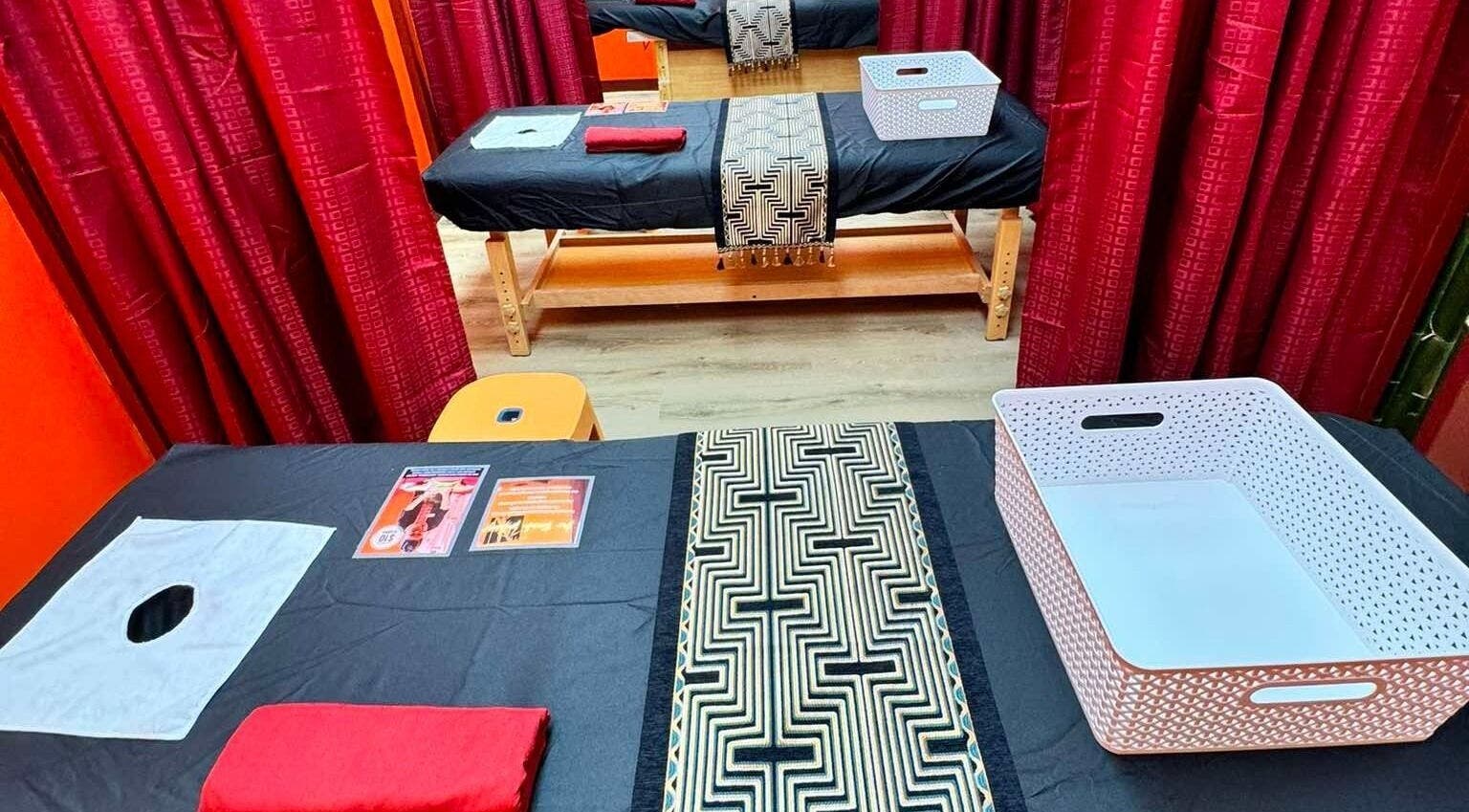 Relaxing massage tables at Bamboo Spa Papakura in Auckland, Auckland, NZ, featuring elegant red curtains.