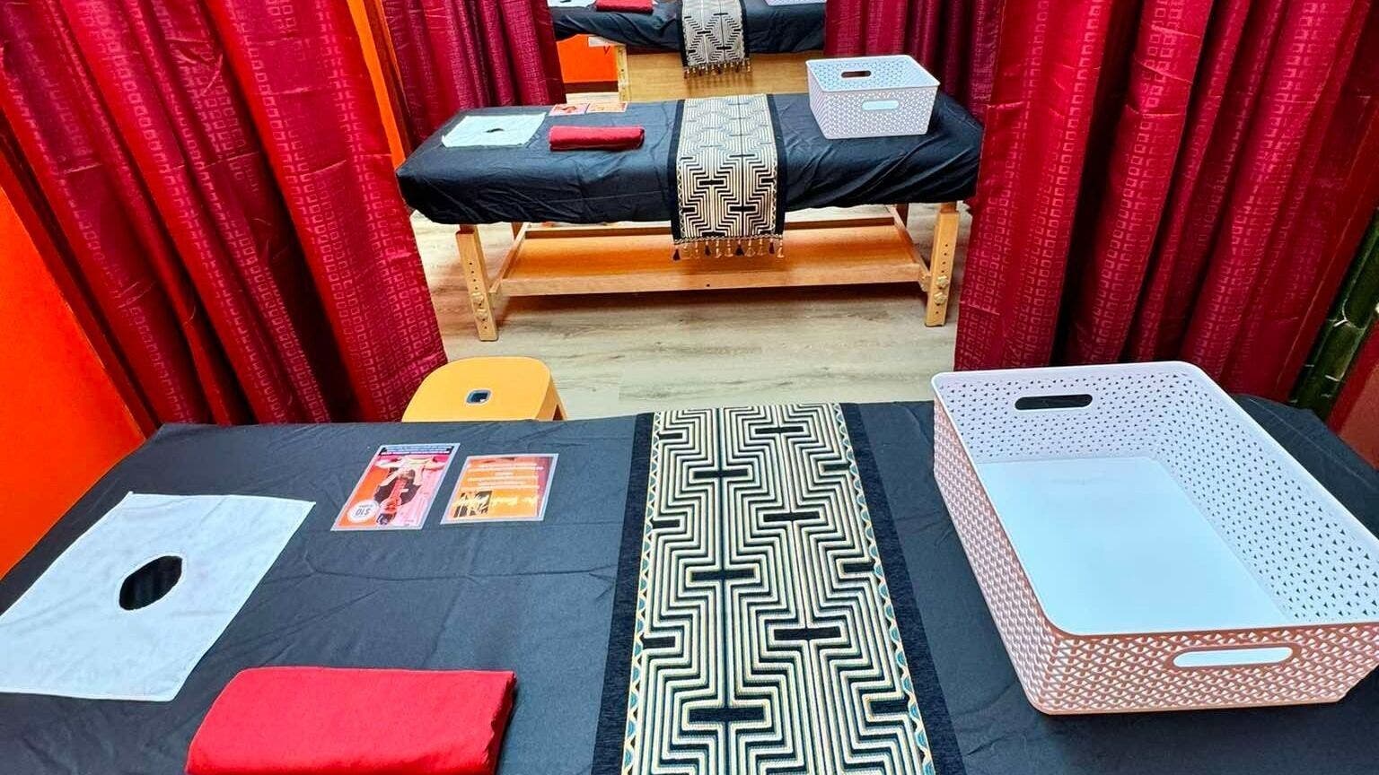 Relaxing massage tables at Bamboo Spa Papakura in Auckland, Auckland, NZ, featuring elegant red curtains.