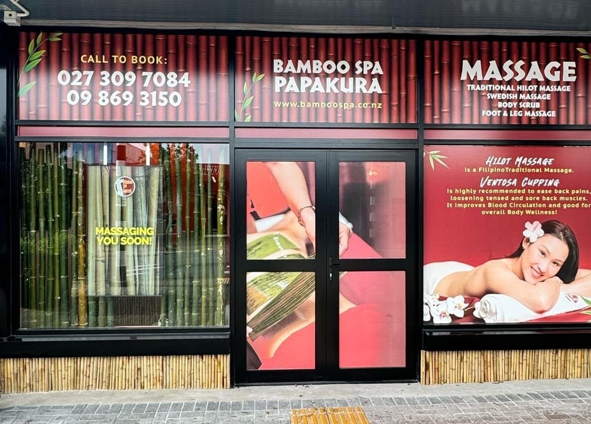 Exterior of Bamboo Spa Papakura in Auckland, NZ, showcasing inviting entrance with massage ads.