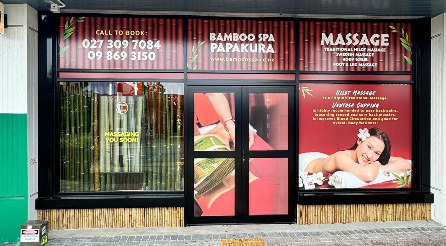 Exterior of Bamboo Spa Papakura in Auckland, NZ, showcasing inviting entrance with massage ads.
