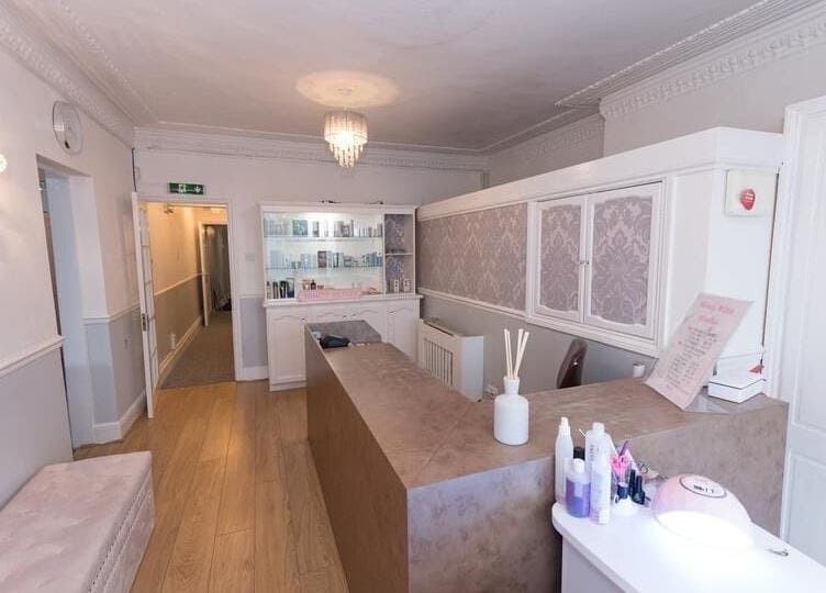 Reception area at Beauty Within, Bristol, England, GB with chic decor and skincare products on display.