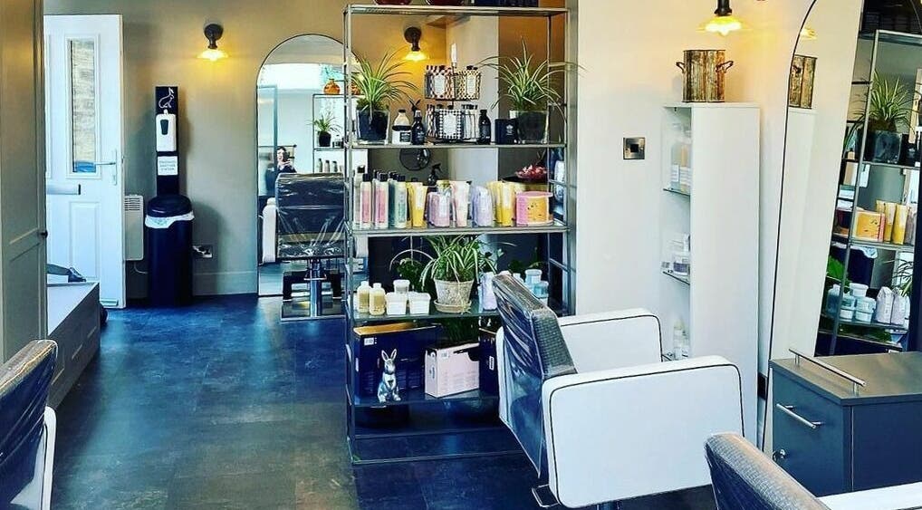 Stylish interior of Currently Hair salon in Leeds, England showcasing modern chairs and product shelves.