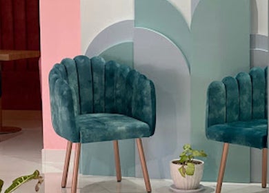 Stylish teal chairs at Hola Spa and Cafe, Al Batinah South Governorate, OM offer a serene ambiance.