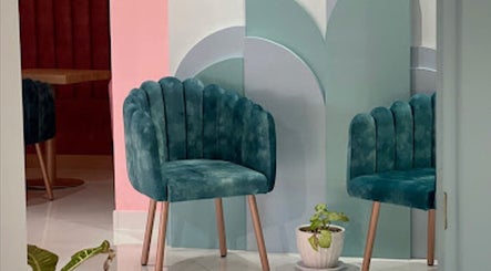 Stylish teal chairs at Hola Spa and Cafe, Al Batinah South Governorate, OM offer a serene ambiance.