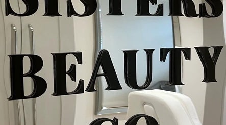 Sleek mirrored wall with 'Sisters Beauty Co.' logo in Costock, England, GB. Modern decor accents beauty.