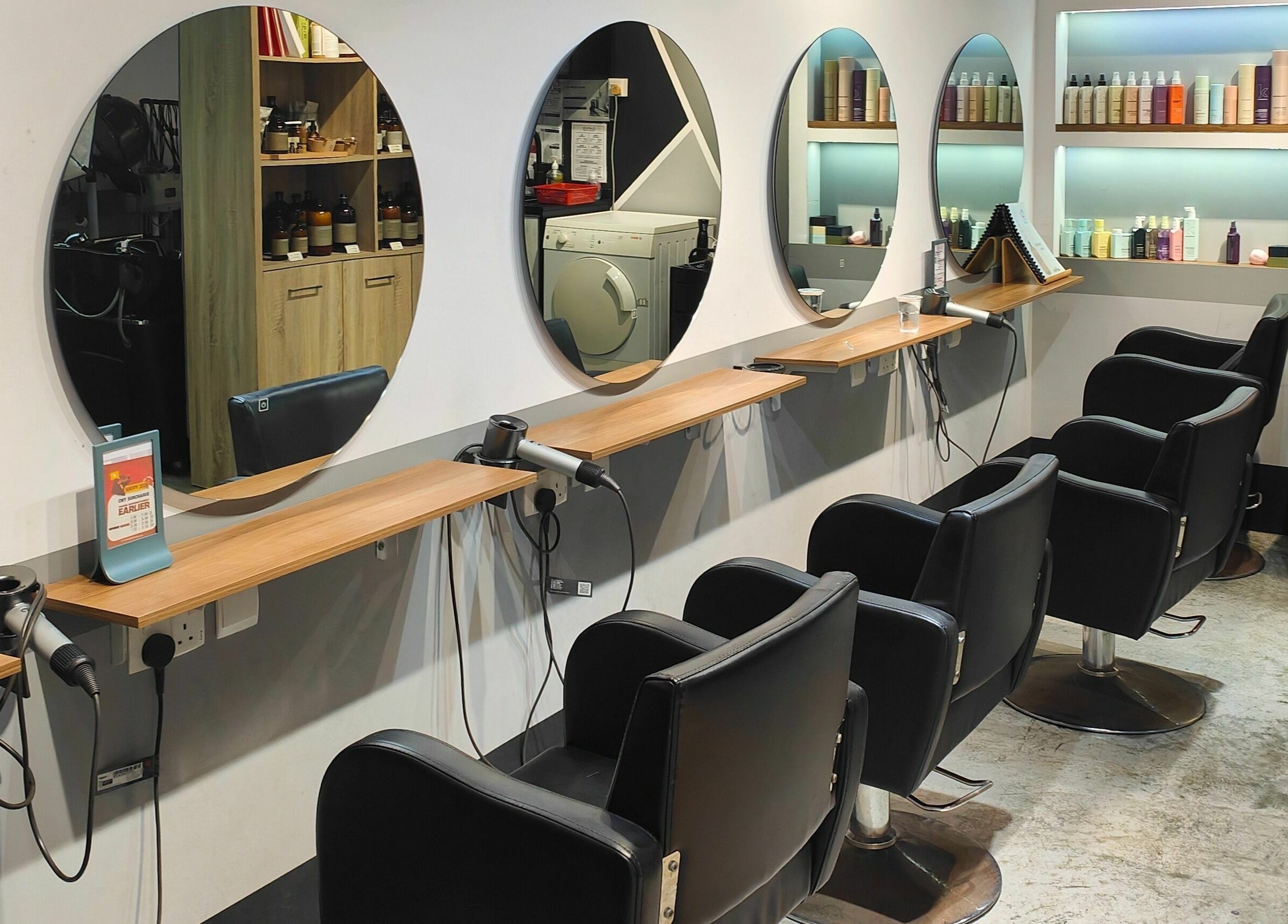 Elegant salon setup at Hair by Common Studio - Queenstown, Singapore, SG featuring stylish mirrors and chairs.