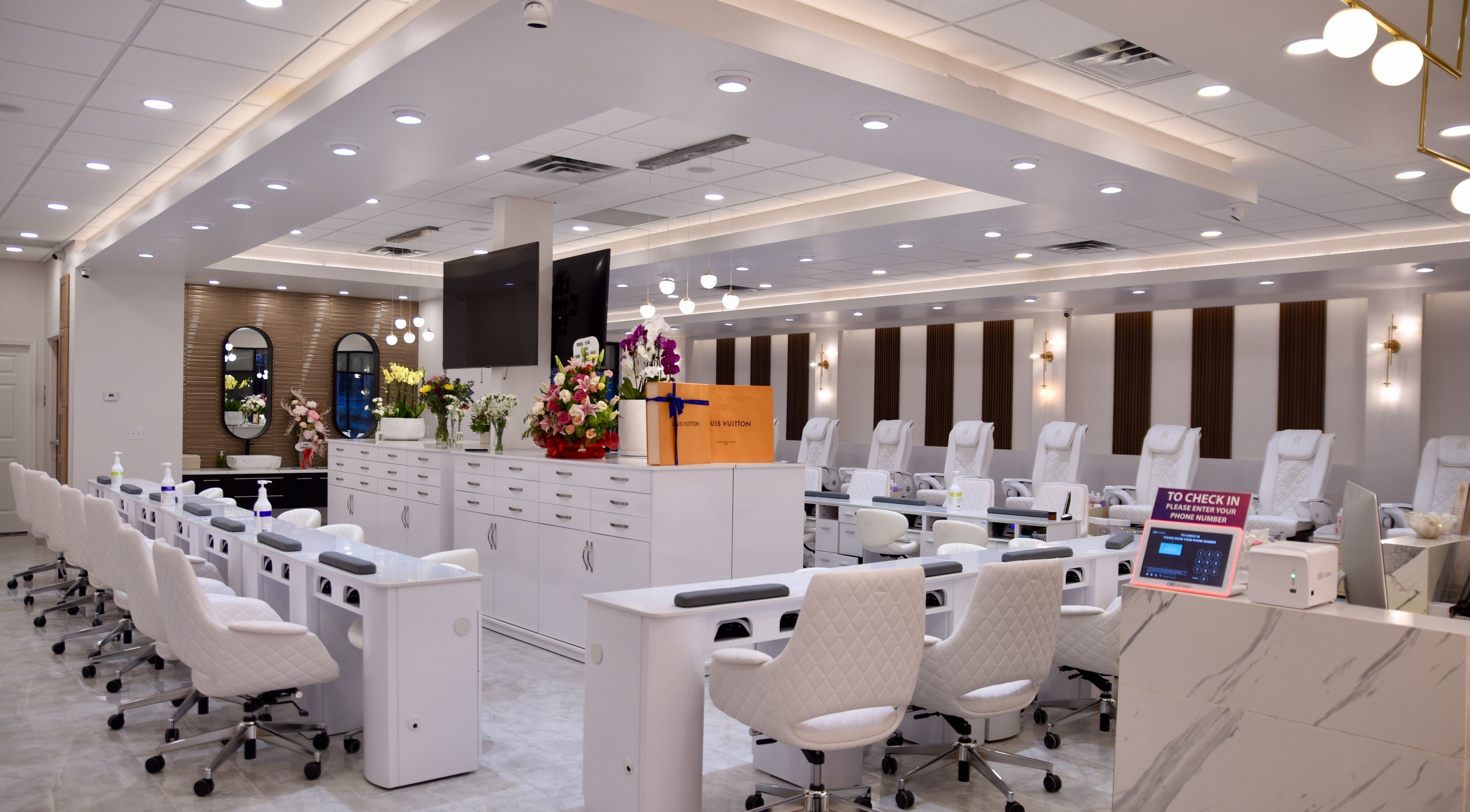 Interior of NT Nail Lab in Sauk Rapids, Minnesota, US, featuring sleek white nail stations and modern decor.
