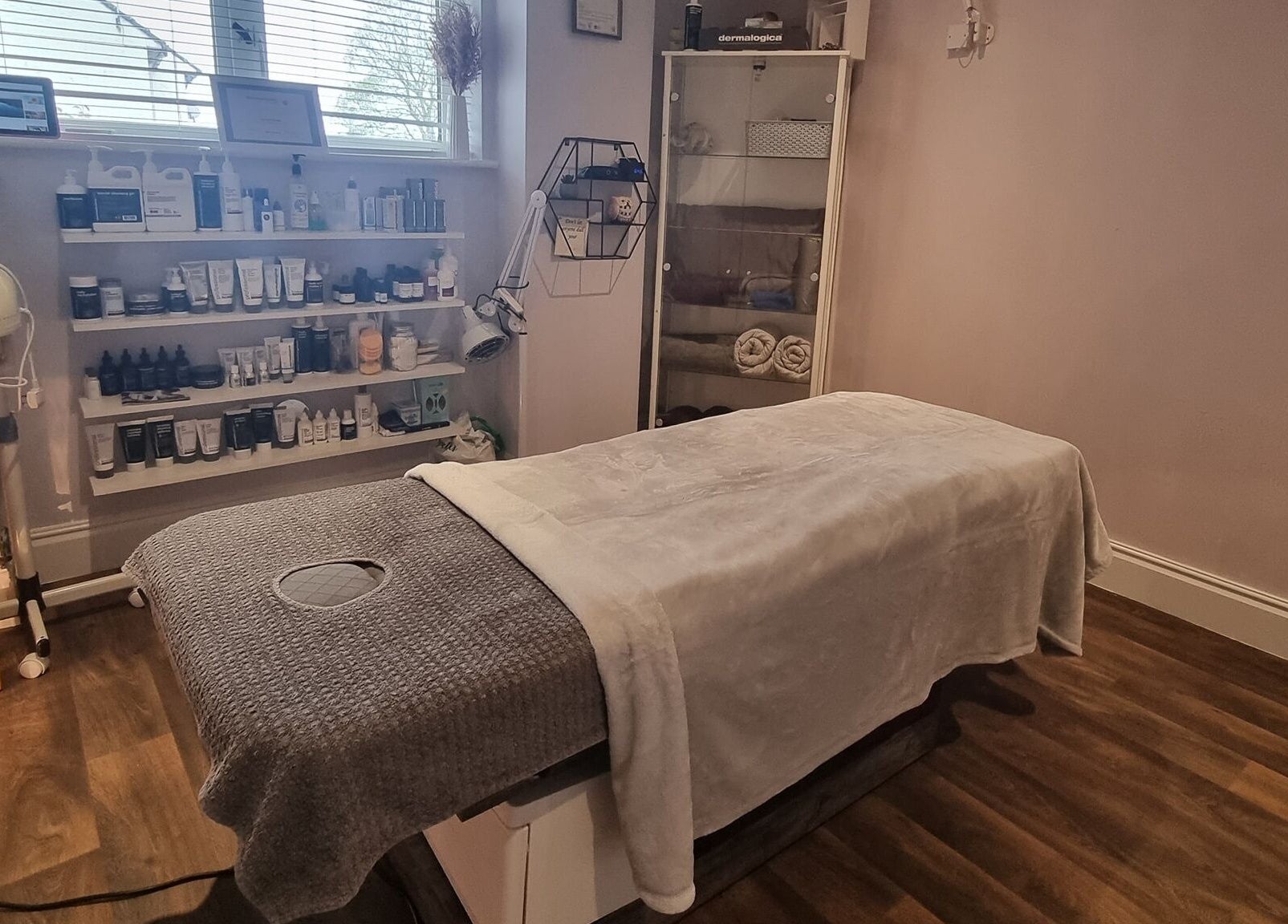 Relaxing treatment room at Body & Mind by Hannah, Douglas, Douglas, IM, showcasing skincare products and a massage table.