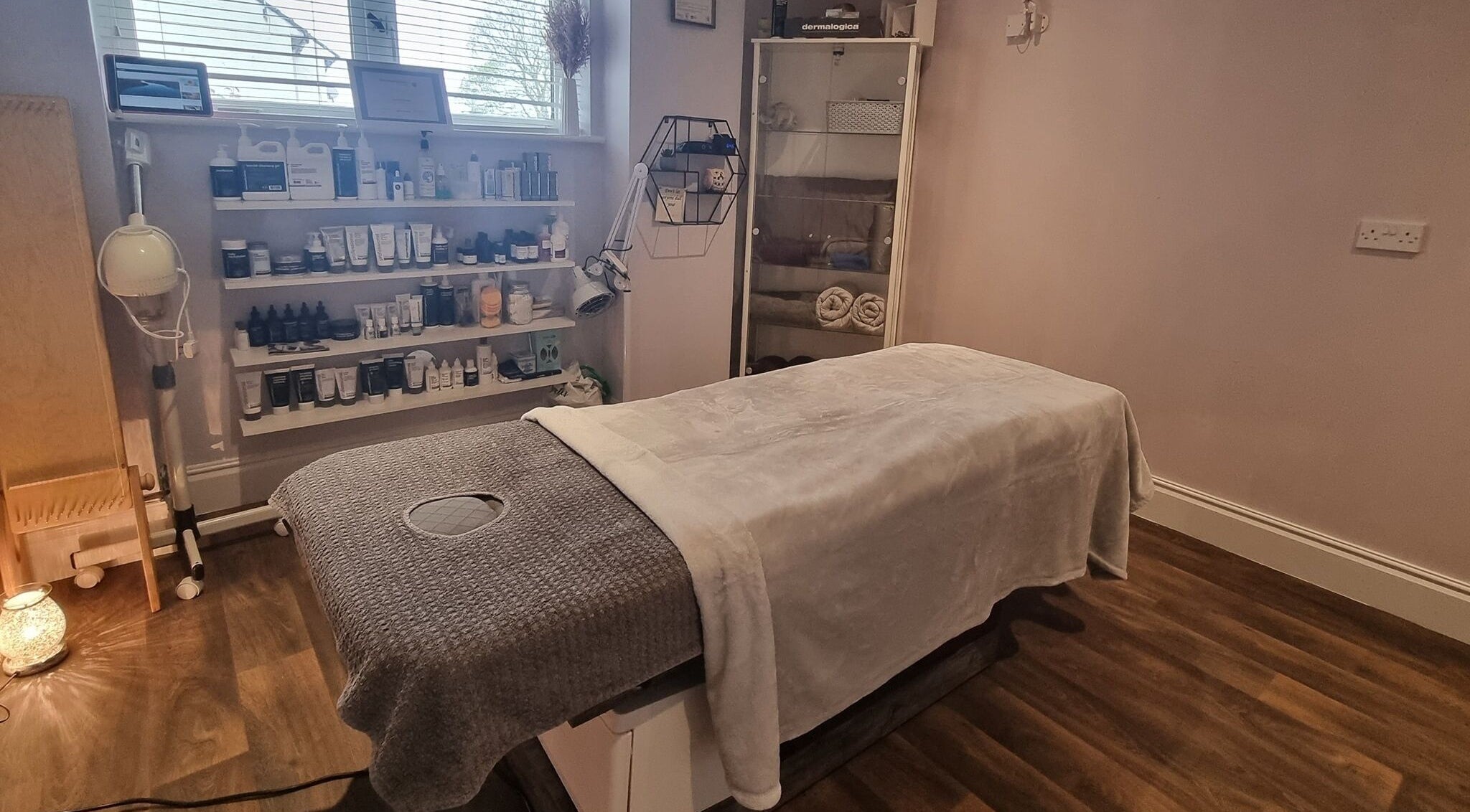 Relaxing treatment room at Body & Mind by Hannah, Douglas, Douglas, IM, showcasing skincare products and a massage table.