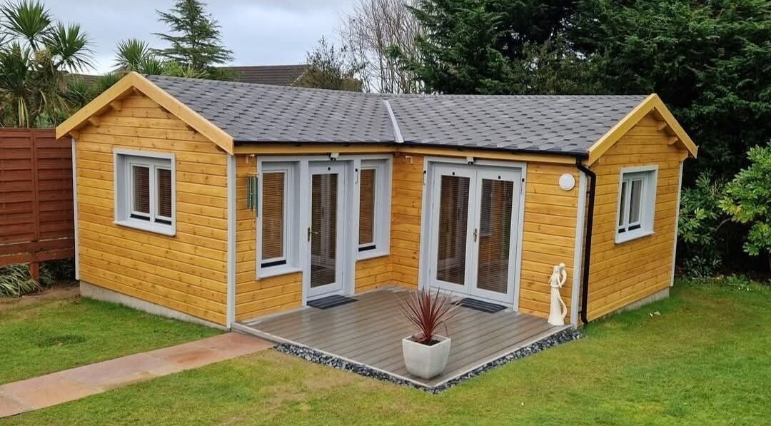 Charming wooden cabin at Body & Mind by Hannah in Douglas, Douglas, IM, surrounded by lush greenery.