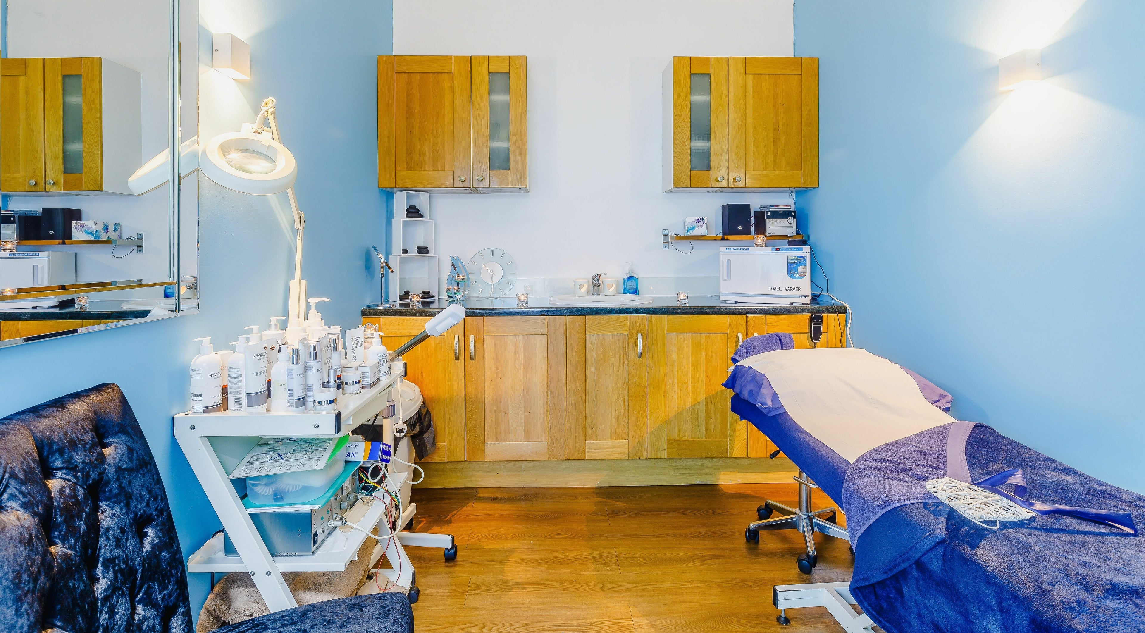 Relaxing treatment room at Cazelle Beauty and Wellbeing, Ruislip, England, GB with massage table and skincare products.