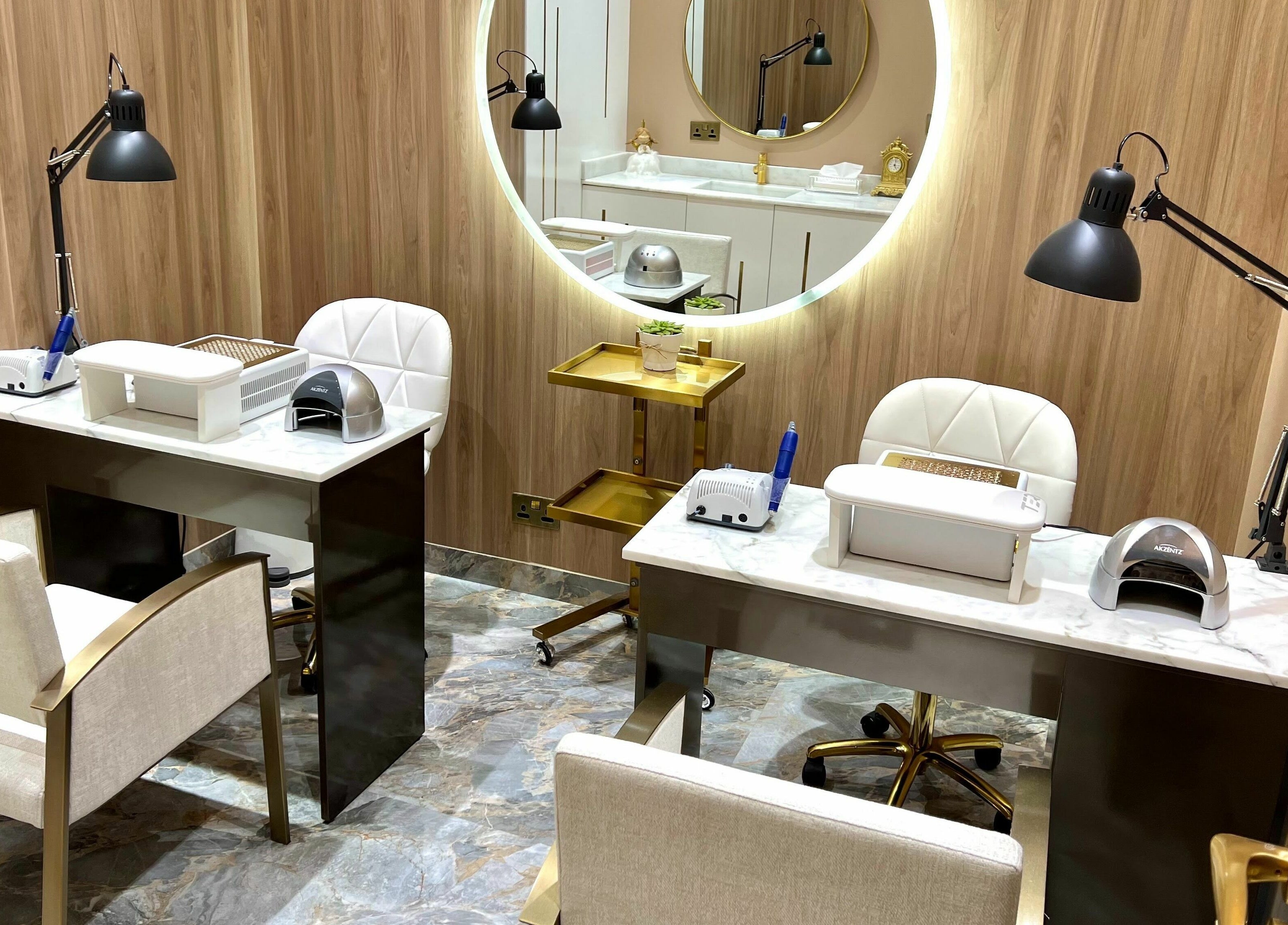 Elegant nail care space at The Beauty House by Takhmina Usmani, Dubai, AE with plush chairs and modern decor.