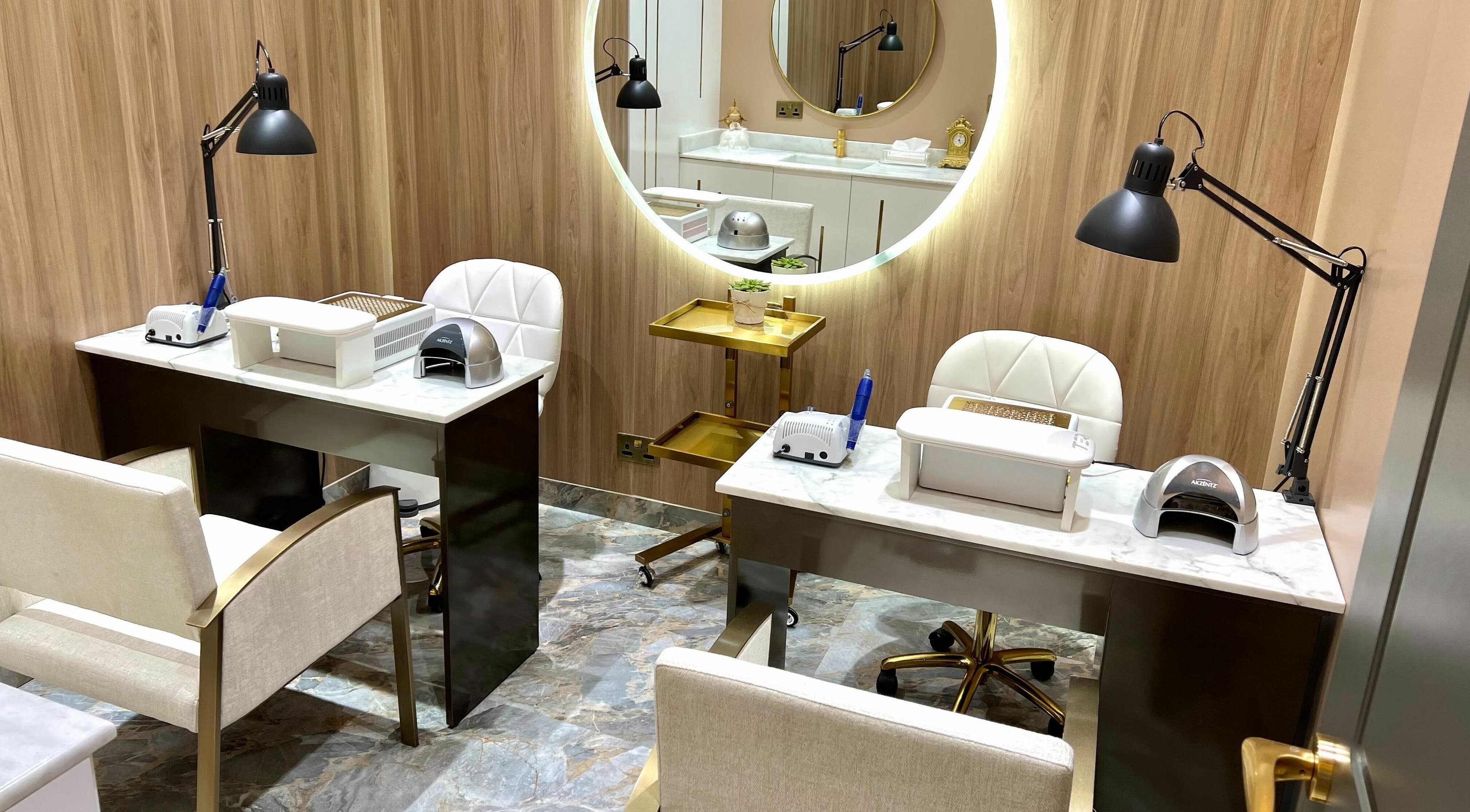 Elegant nail care space at The Beauty House by Takhmina Usmani, Dubai, AE with plush chairs and modern decor.