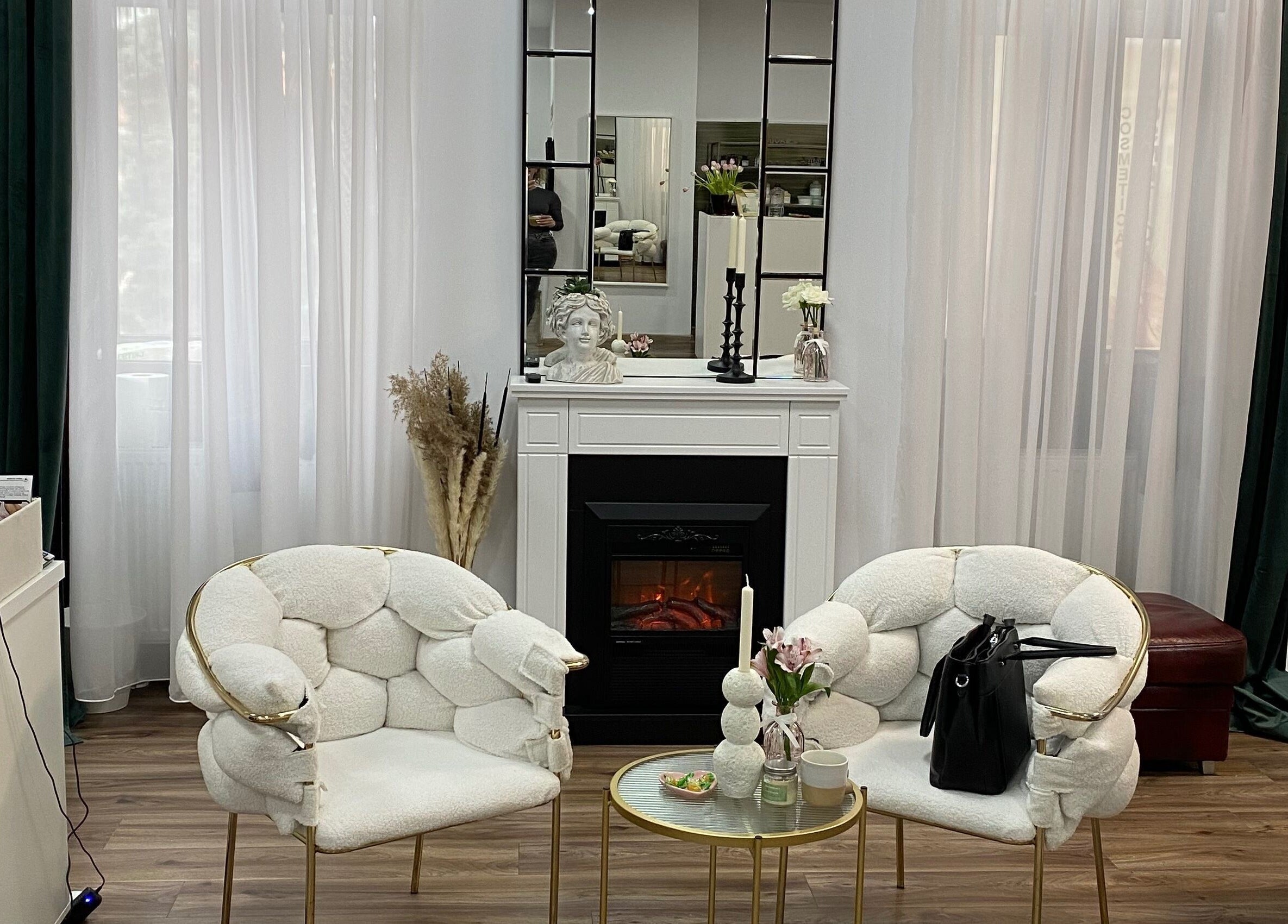 Lounge stilat la Infinity Beauty Salon, Târgu Mureș, Județul Mureș, RO, cu fotolii albe și șemineu.