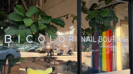 Bright window view of Bicolor Los Feliz nail boutique in Los Angeles, California, US with plants and rainbow decor.
