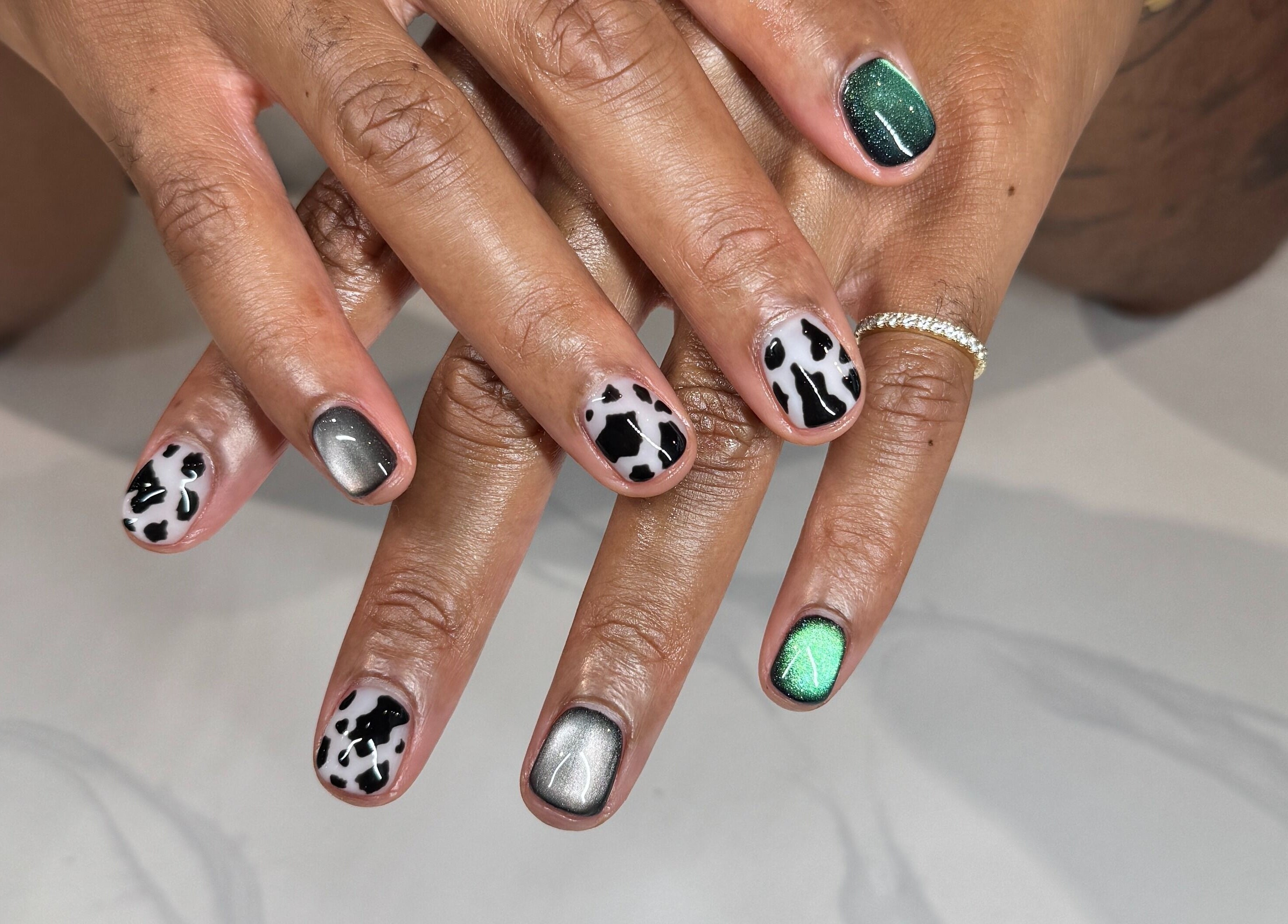 Trendy nail art with cow print and metallic polish at Bicolor Beverly Hills in Beverly Hills, California, US.