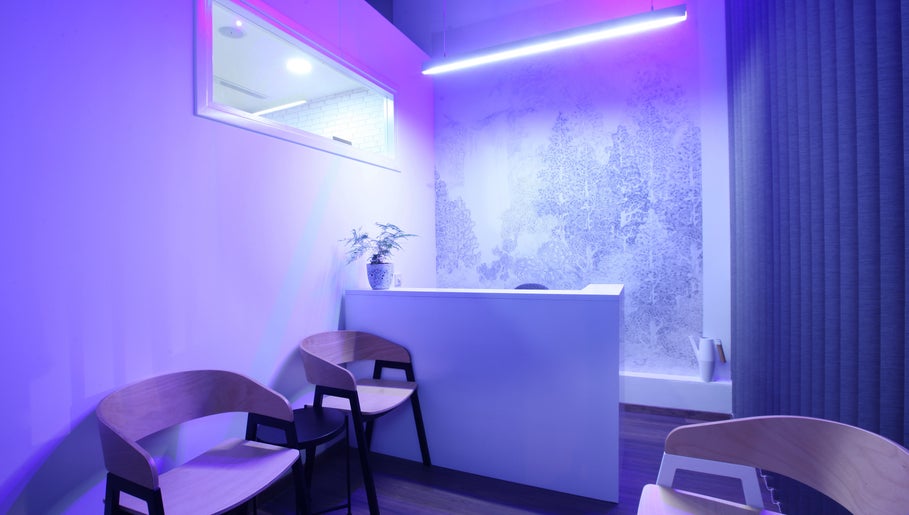 Modern reception area of Sancti Studio, Nicosia, CY with purple lighting and stylish design.