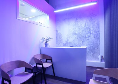 Modern reception area of Sancti Studio, Nicosia, CY with purple lighting and stylish design.