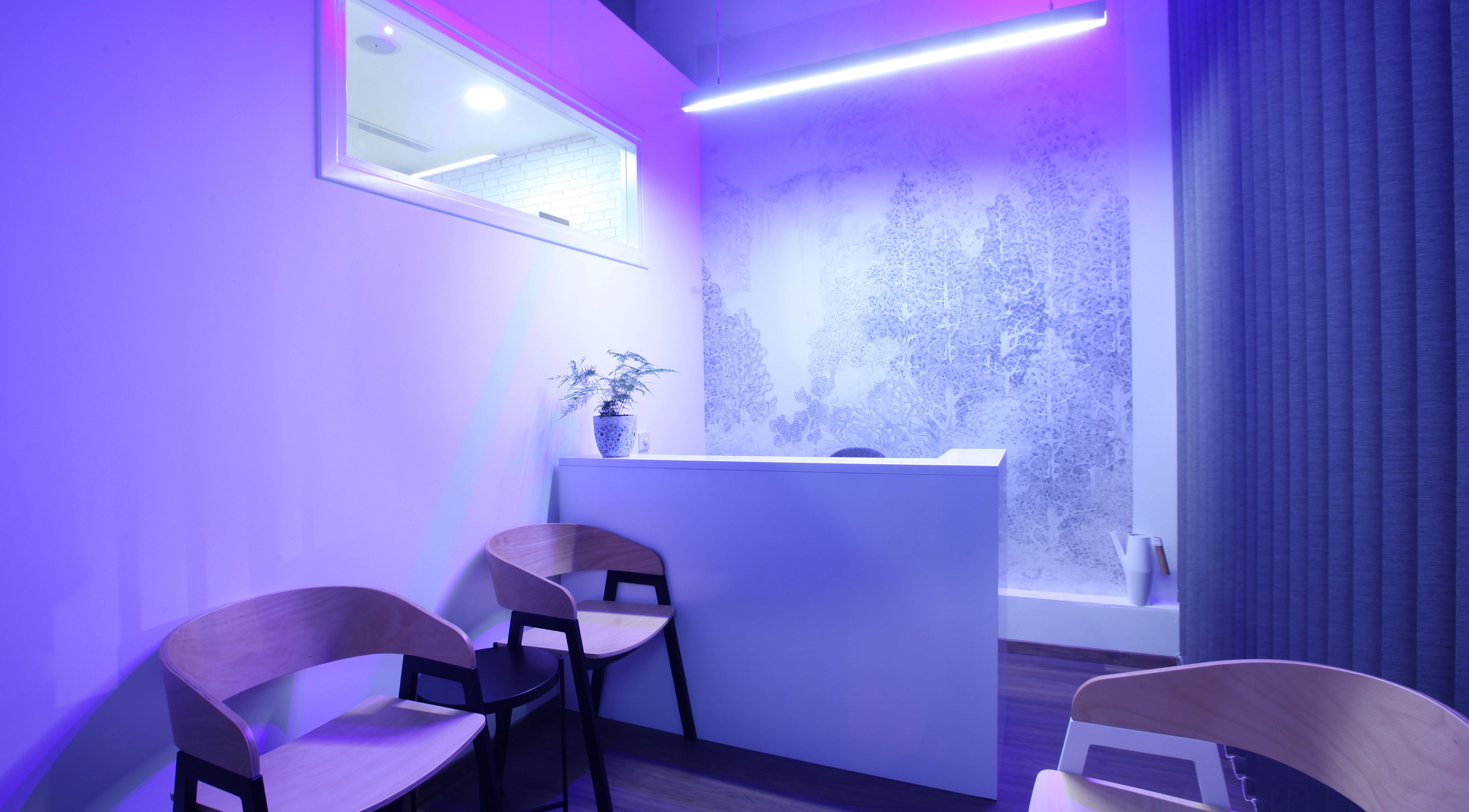 Modern reception area of Sancti Studio, Nicosia, CY with purple lighting and stylish design.