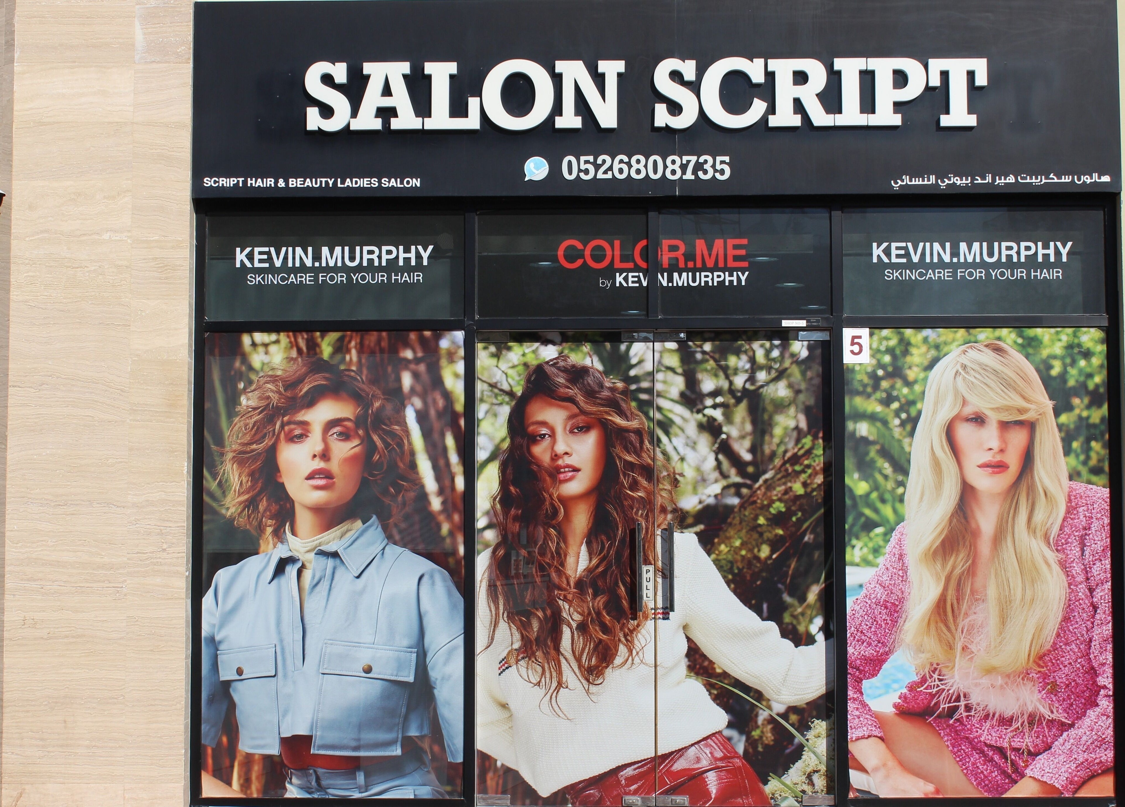 Exterior of Salon Script in Dubai, AE, showcasing vibrant hair models and beauty services.