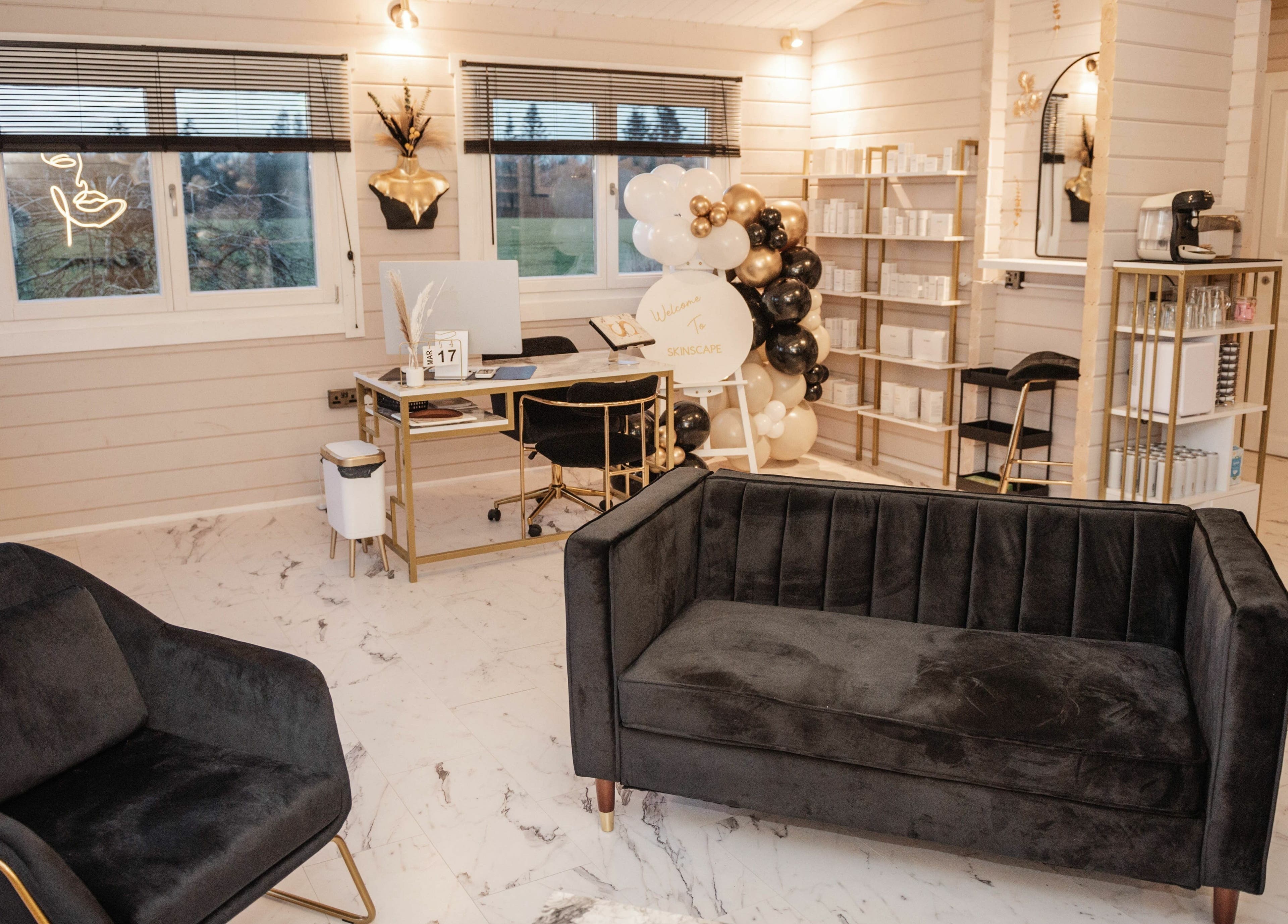 Chic interior of Skinscape Aesthetics & Beauty Kelso, KELSO, Scotland, GB featuring sleek black couches and a modern desk.