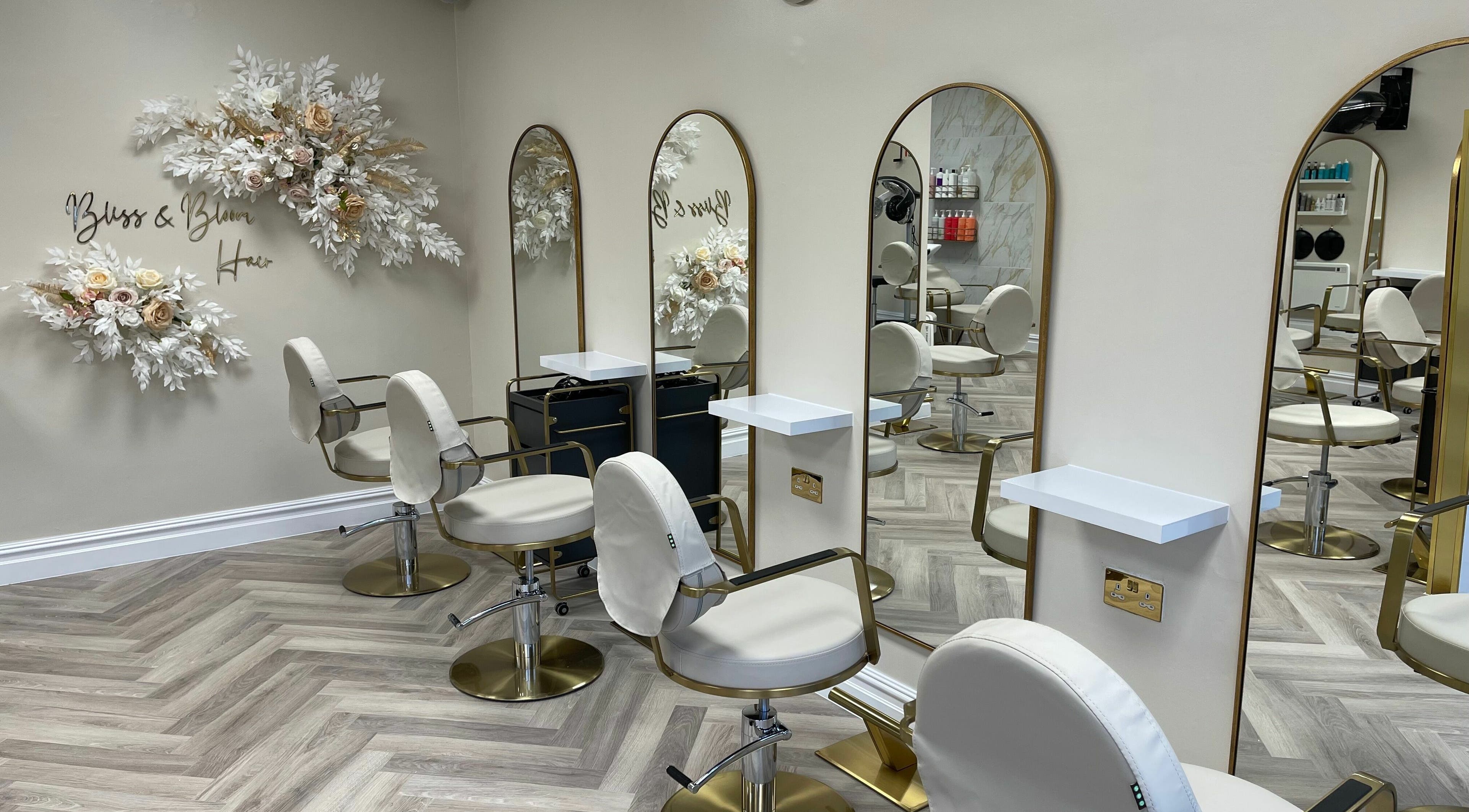Elegant salon interior at Bliss & Bloom Hair, Nether Poppleton, England, GB, featuring modern chairs and floral decor.