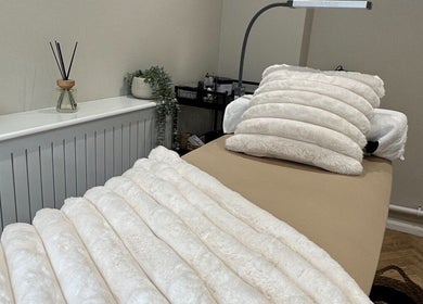 Cozy treatment room at The Beauty Lounge in Thrapston, England, GB with soft white bedding.