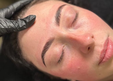 Eyebrow treatment at The Beauty Lounge, Thrapston, England, GB. Gloved hand shaping client's brows.