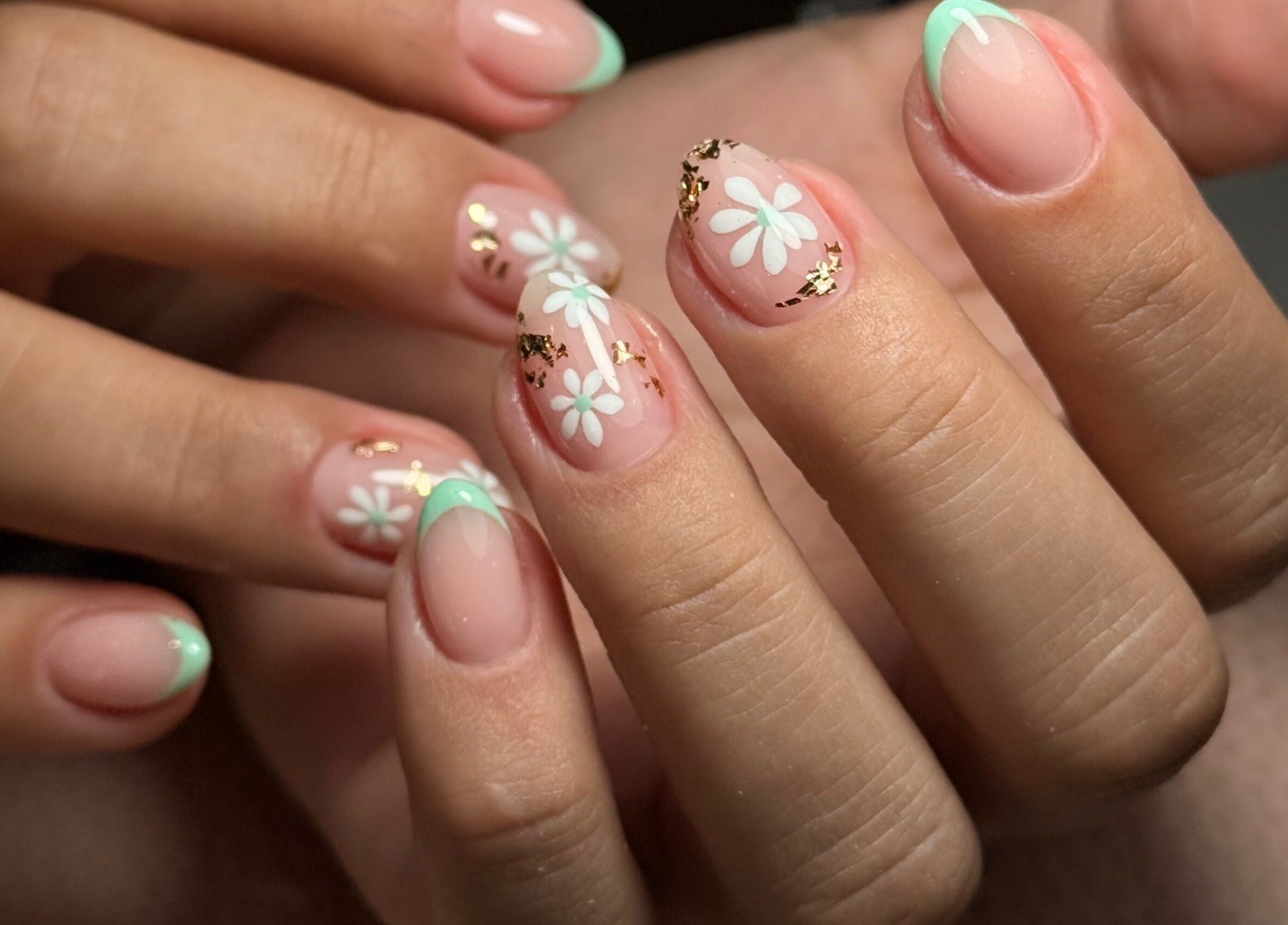 Manicura floral en Tnails, Santiago, Región Metropolitana, CL. Uñas decoradas con flores y detalles dorados.