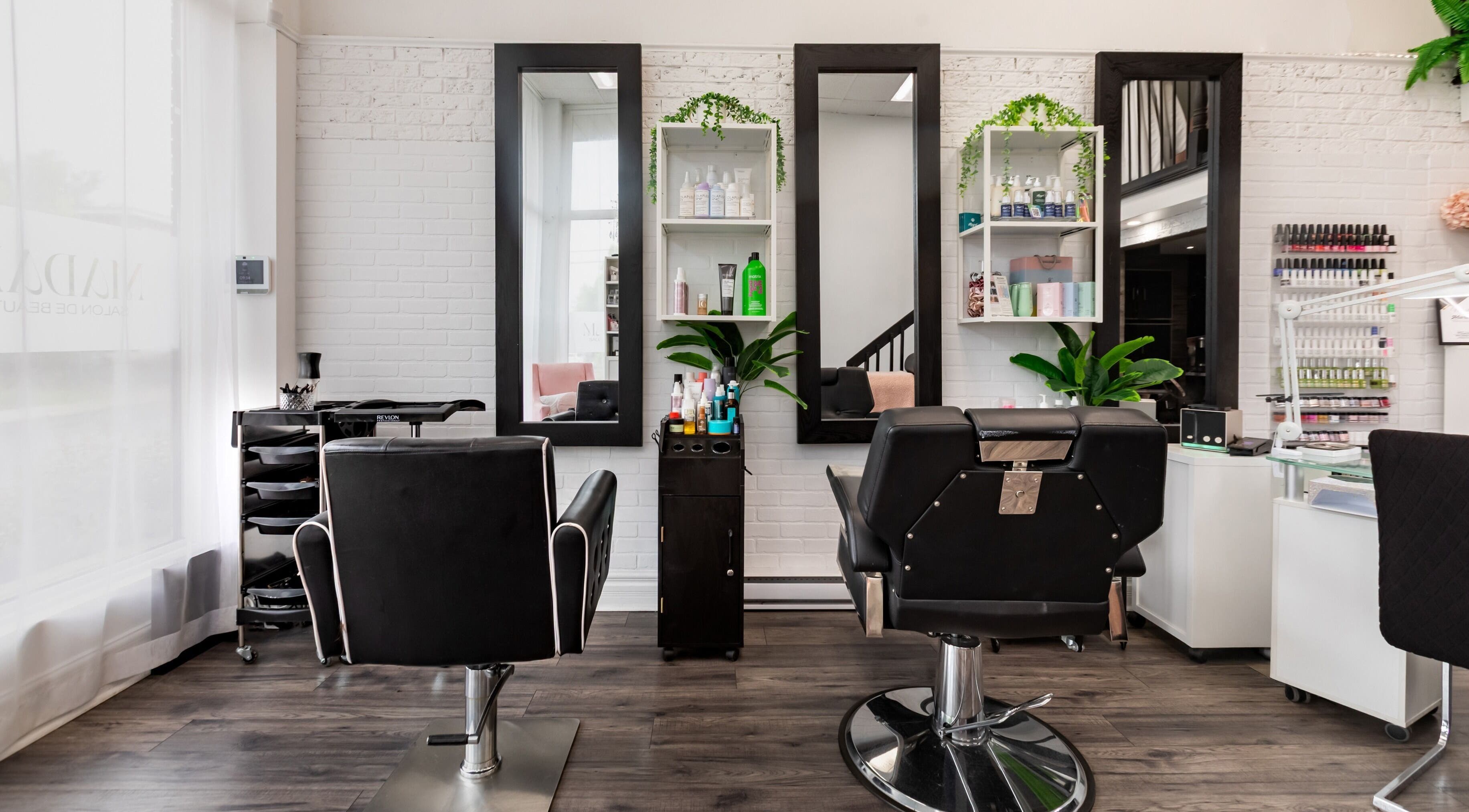 Intérieur élégant de Madam Salon de Beauté, Longueuil, Québec, CA avec miroirs et chaises modernes.