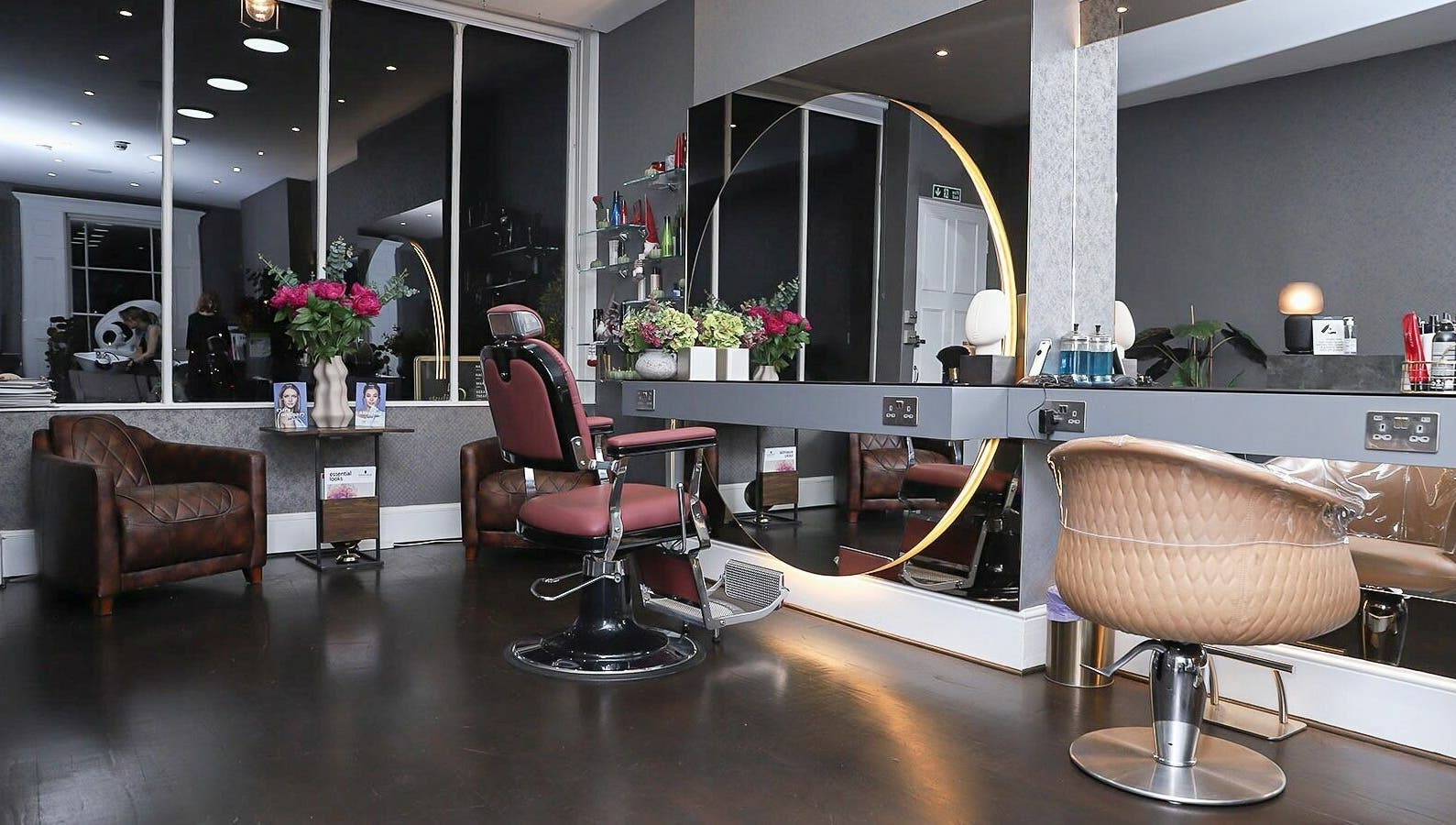 Modern salon interior at Studio 52 Hair and Beauty, London, England, GB, featuring elegant styling chairs and mirrors.