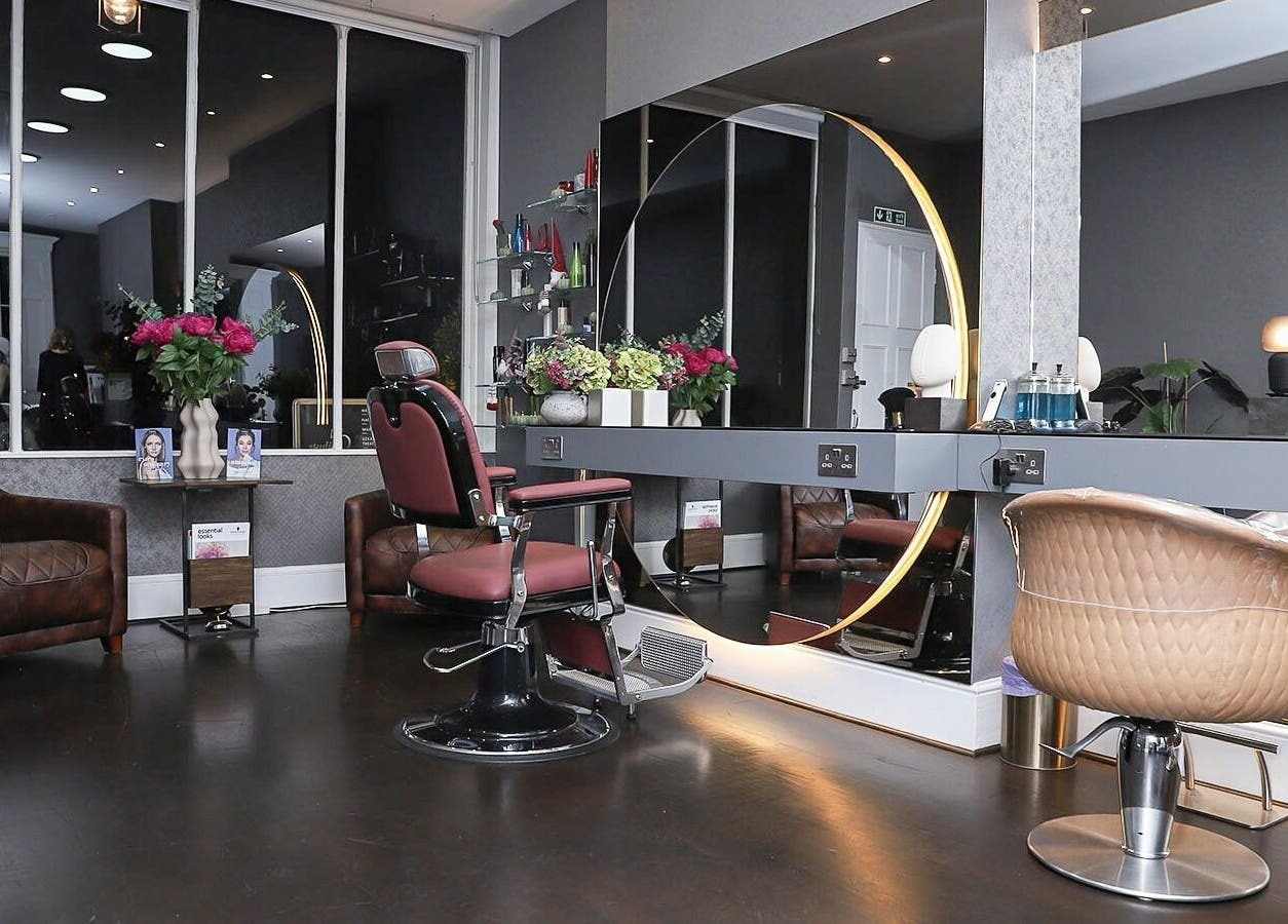 Modern salon interior at Studio 52 Hair and Beauty, London, England, GB, featuring elegant styling chairs and mirrors.